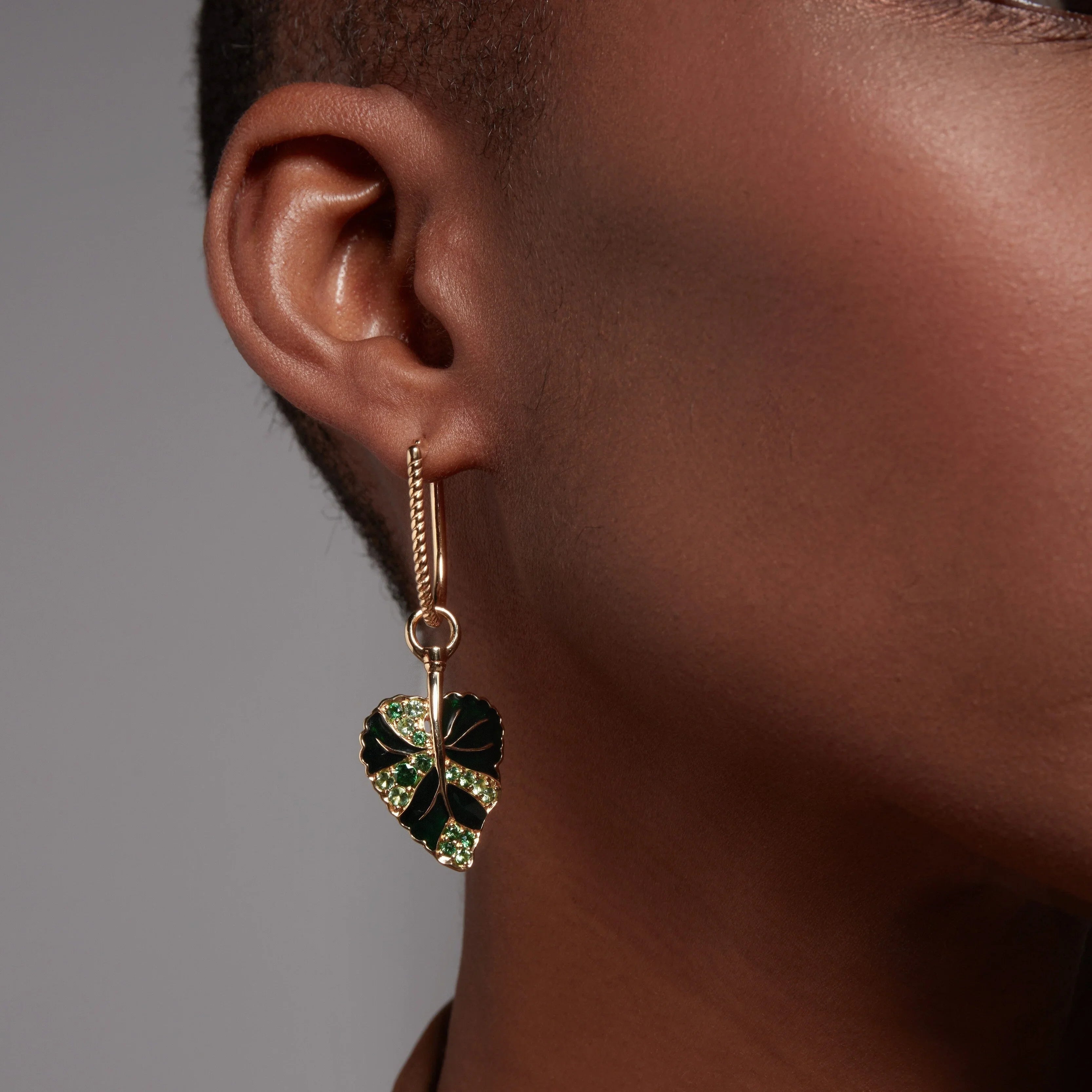 Gold hoop earring with green enamel and gemstone monstera leaf charm