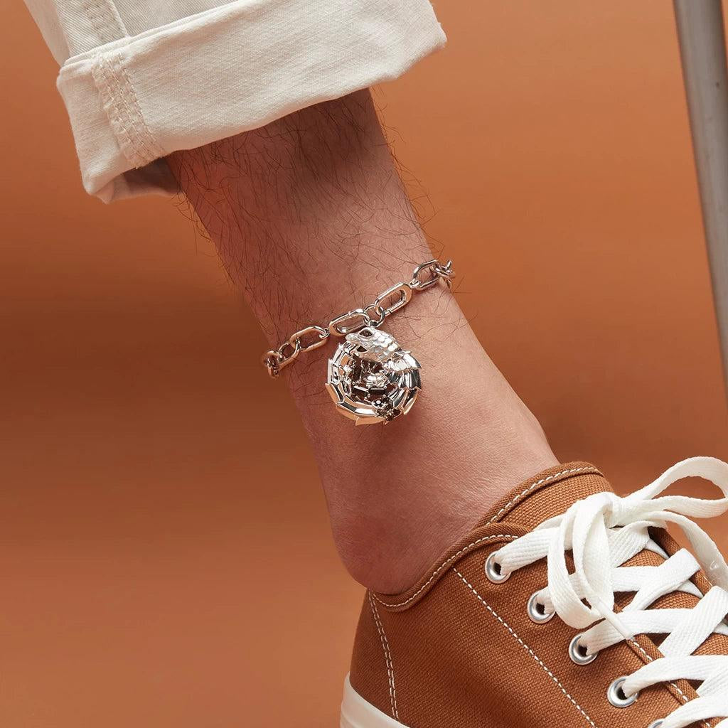 Silver dragon-shaped charm anklet on male ankle with rolled-up pants and sneakers