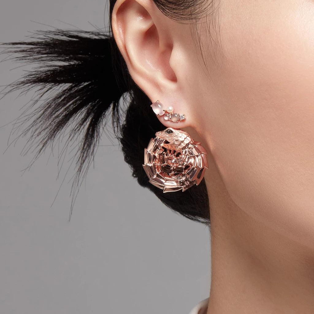 Statement look with silver cluster stud earring and large sculptural rose gold charm worn together for a layered style.