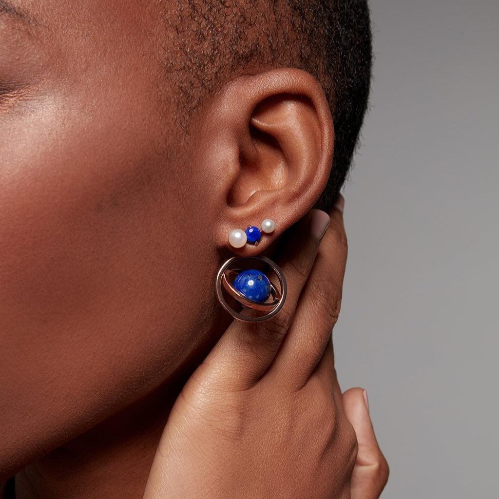 Pearl and lapis lazuli cluster studs paired with bold blue planet-inspired charm.