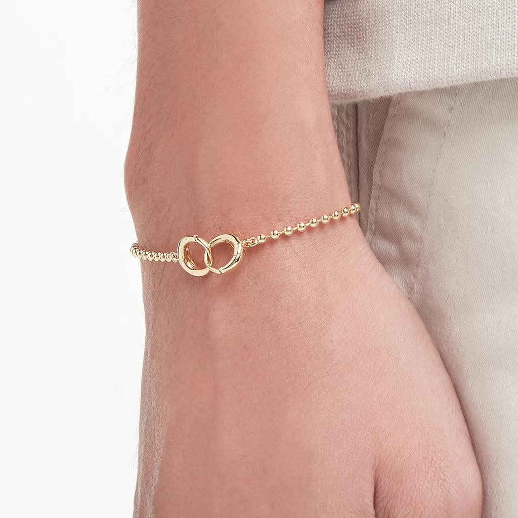 Gold ball chain bracelet with interlocking clasp on wrist