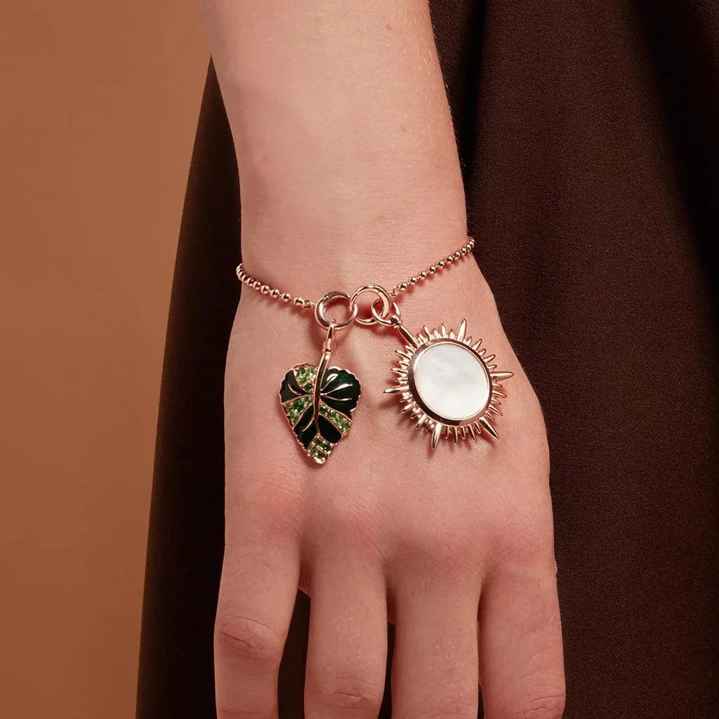 Rose gold charm bracelet with green enamel leaf and radiant sun charms