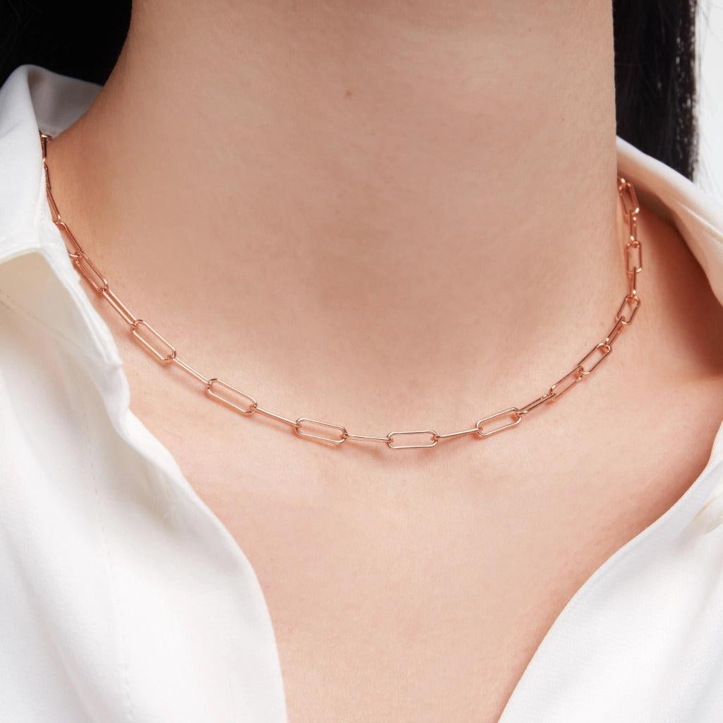 Minimal rose gold paperclip chain choker necklace on model wearing white shirt