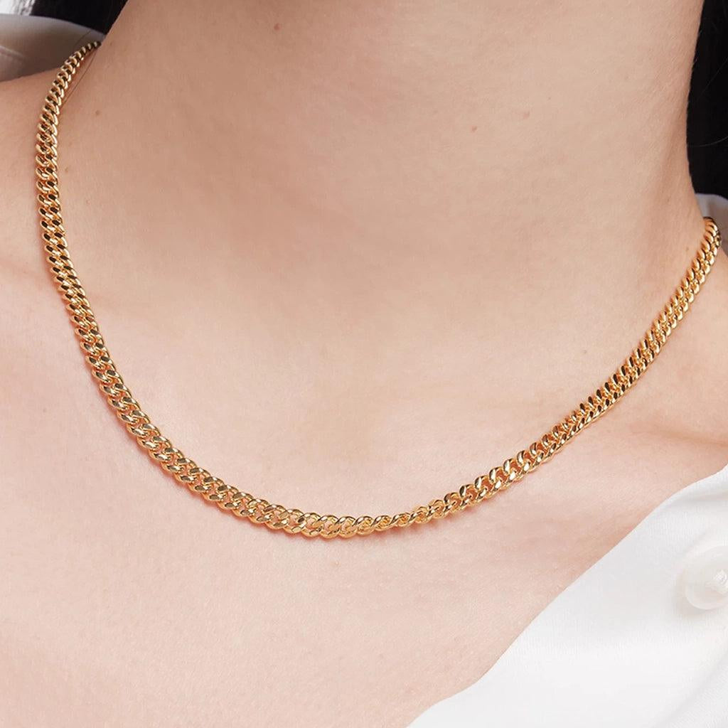 Woman wearing a classic gold curb chain necklace on bare neck.
