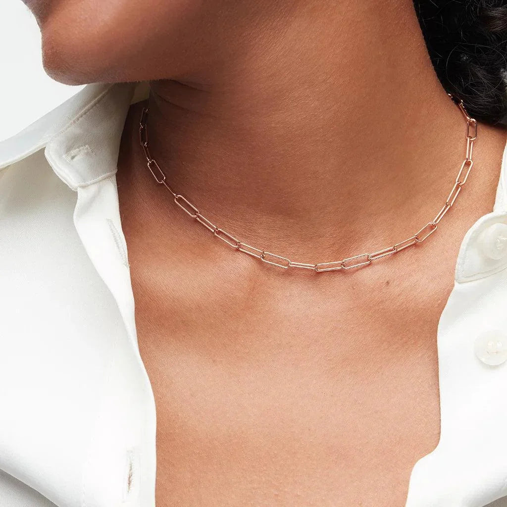 Delicate rose gold link choker necklace styled on woman in white blouse