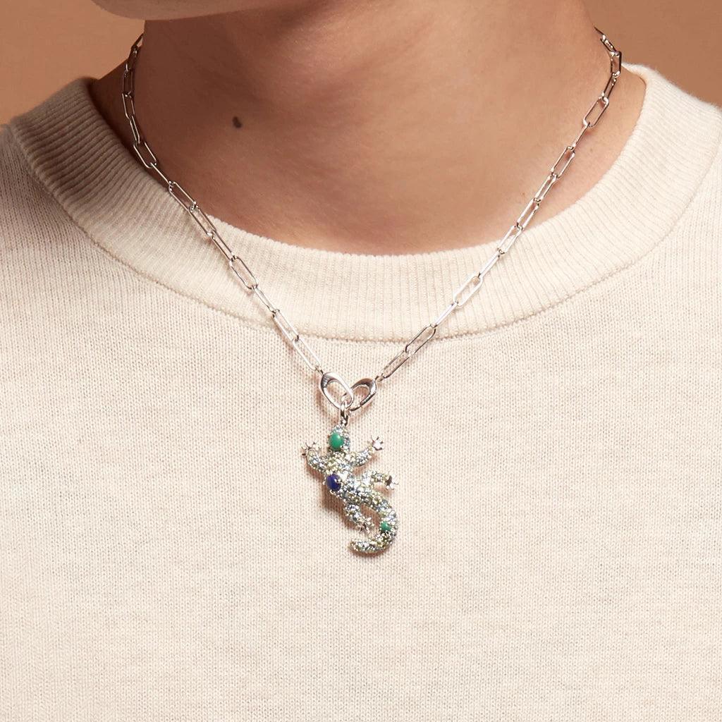 Silver chain necklace with lizard charm pendant worn over beige top