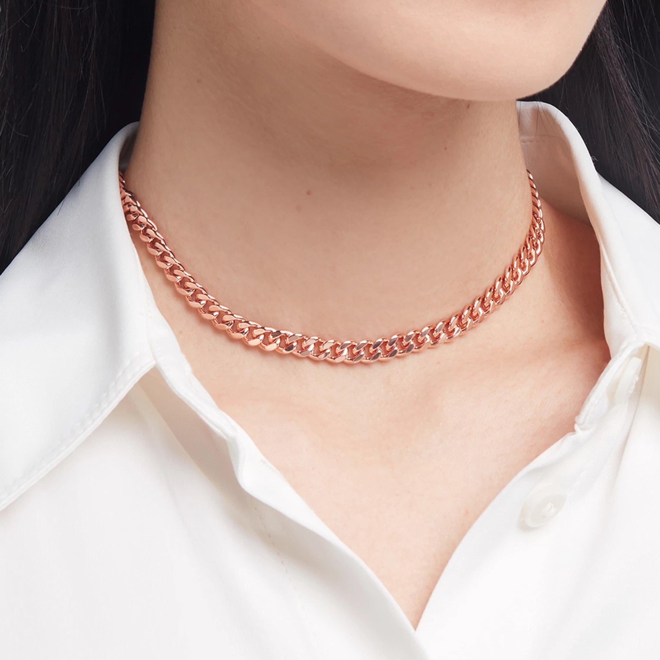 Elegant rose gold Cuban chain choker necklace styled with a crisp white shirt.