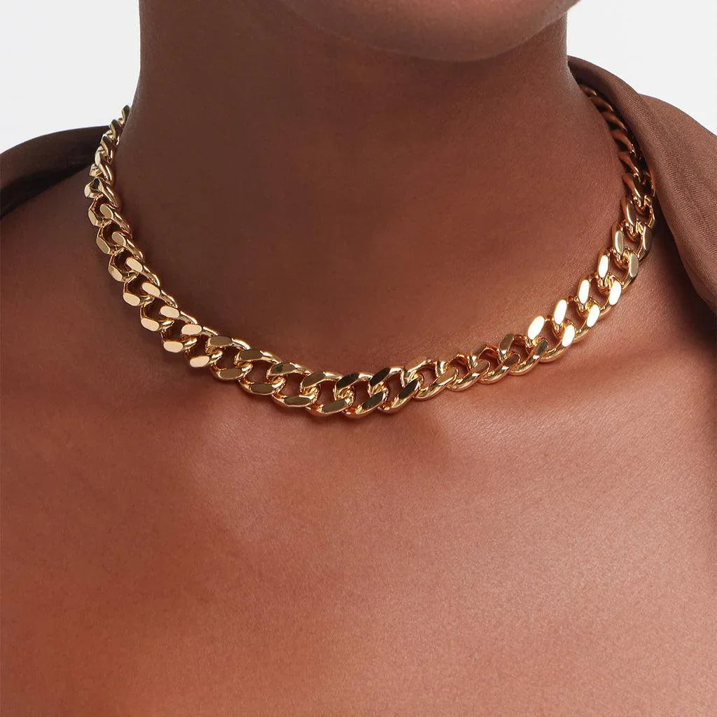 Polished gold Cuban chain choker on model’s neck