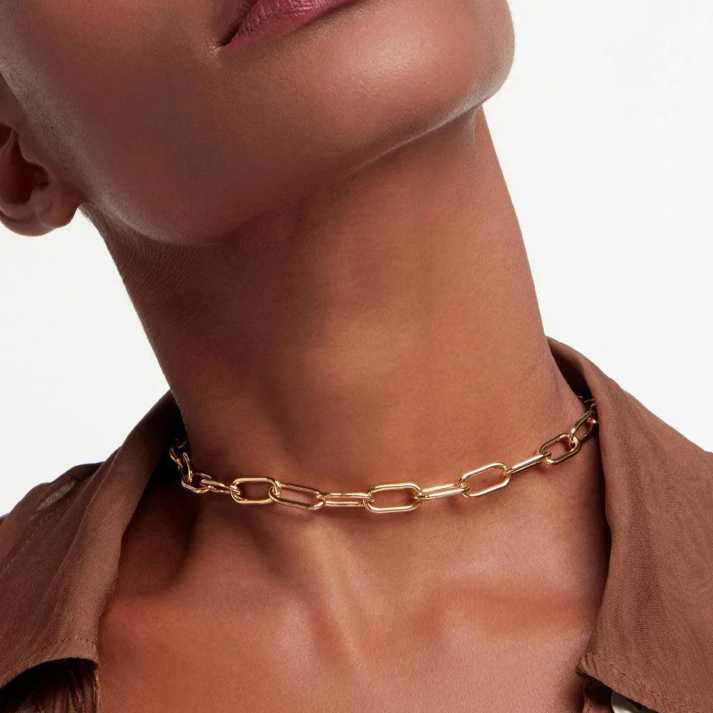 Gold paperclip chain choker necklace on model with brown shirt