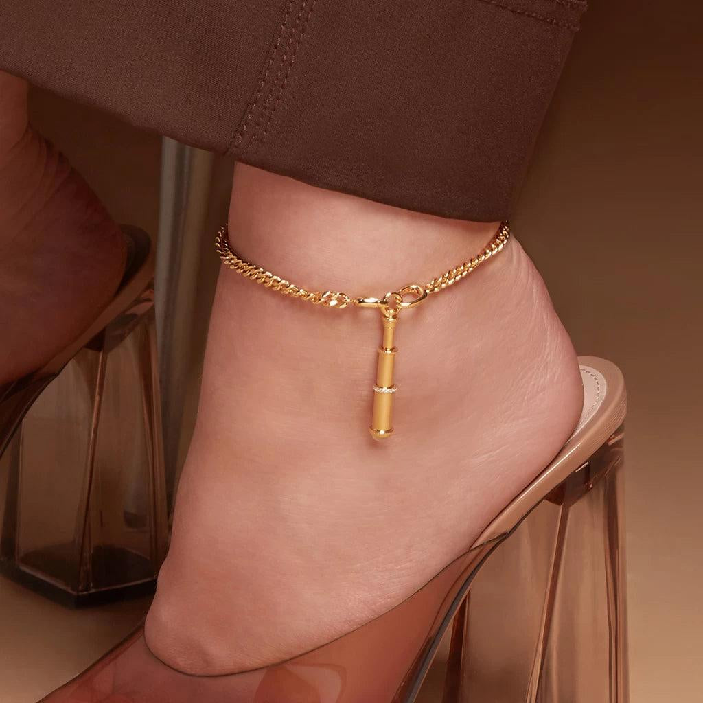 Bold gold anklet with vertical bar charm styled with lucite block heels