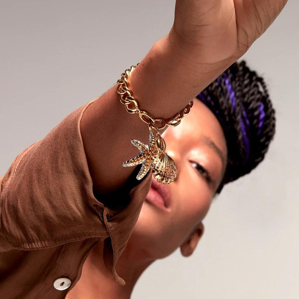 Gold chain bracelet with sea-inspired starfish and seashell charms
