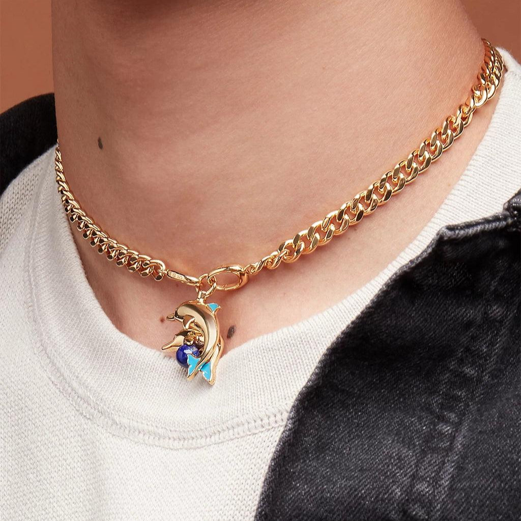 Gold Cuban choker necklace featuring a dolphin charm with blue gemstone accents.