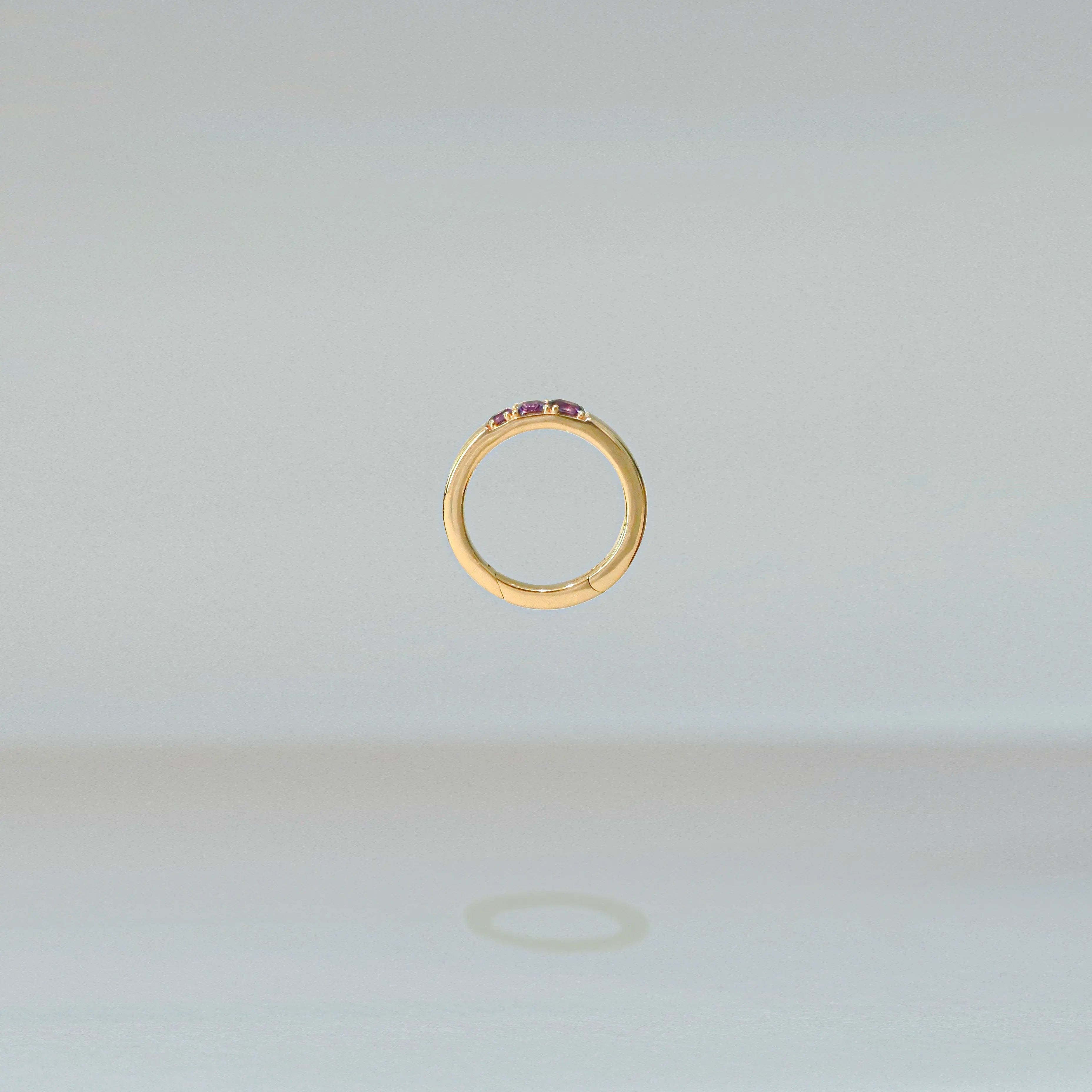 Gold ring with embedded stones on a light gray background