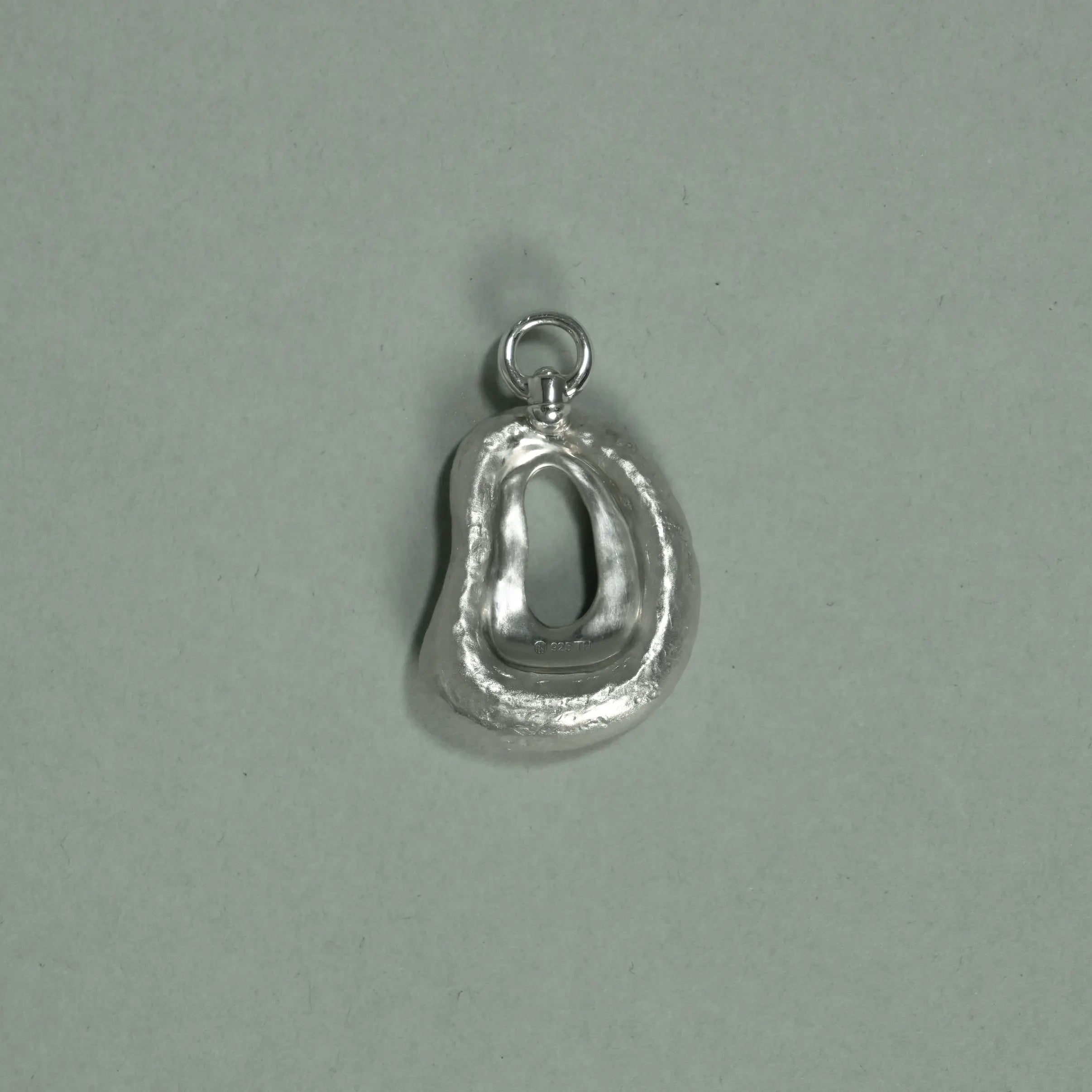 Silver pendant on a light gray background