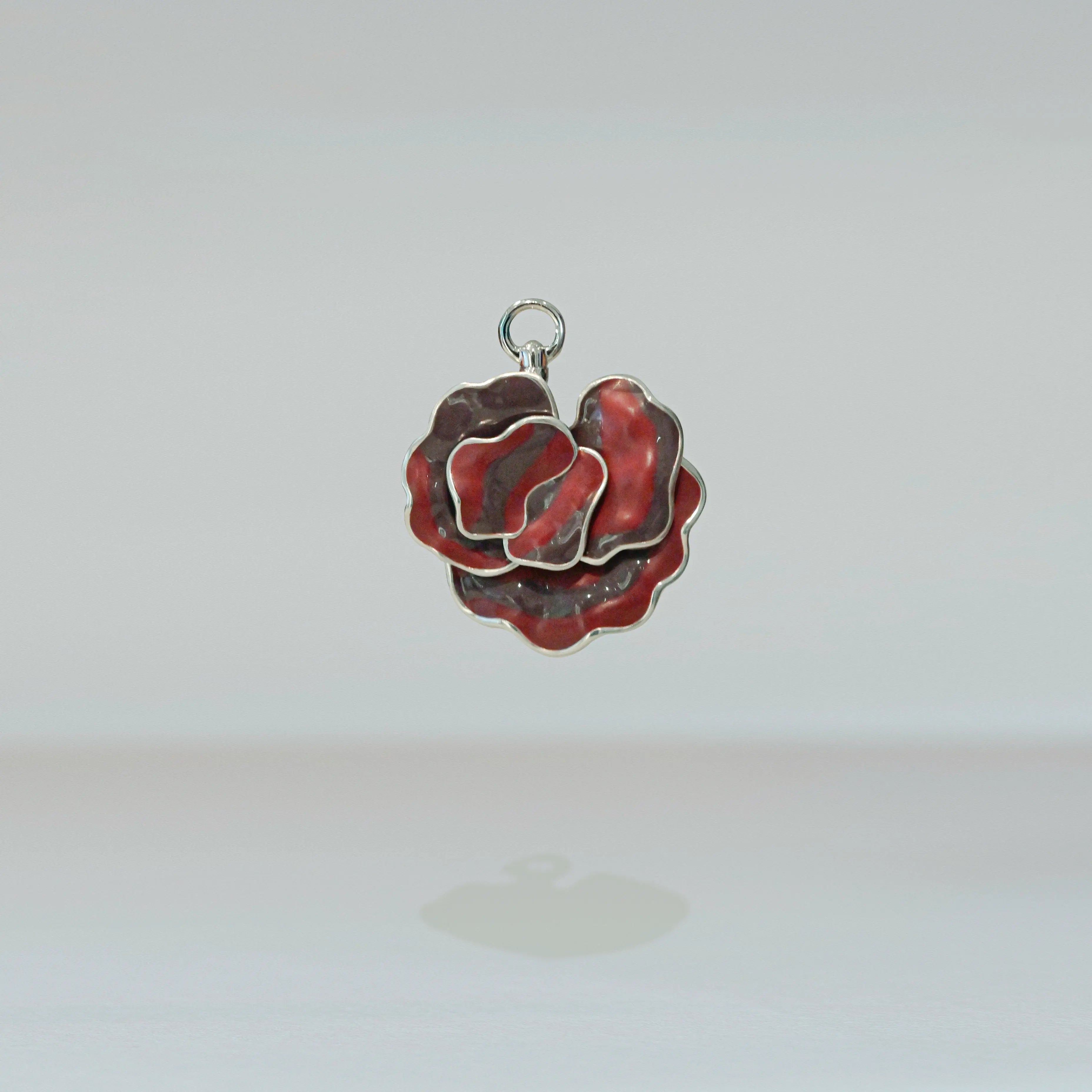 Red and silver rose-shaped pendant on a white background