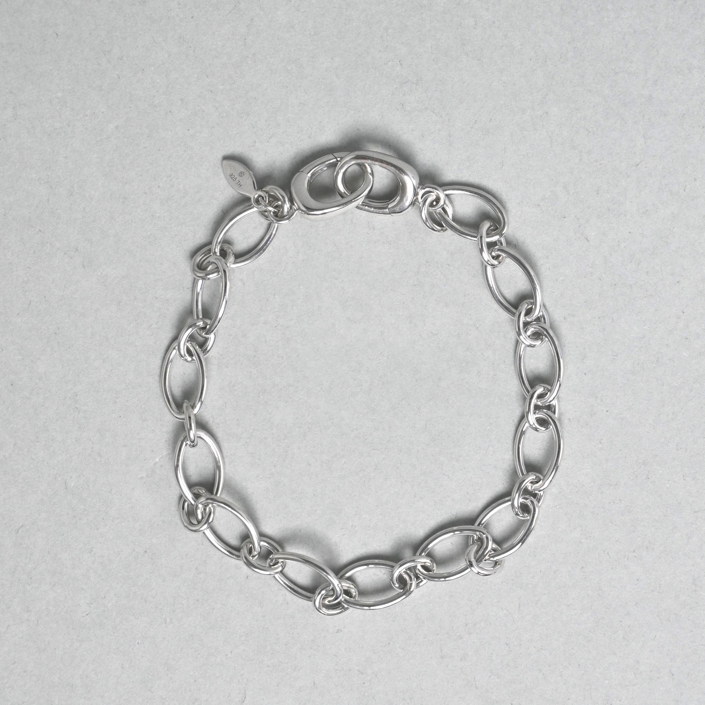Silver chain bracelet on a light gray background