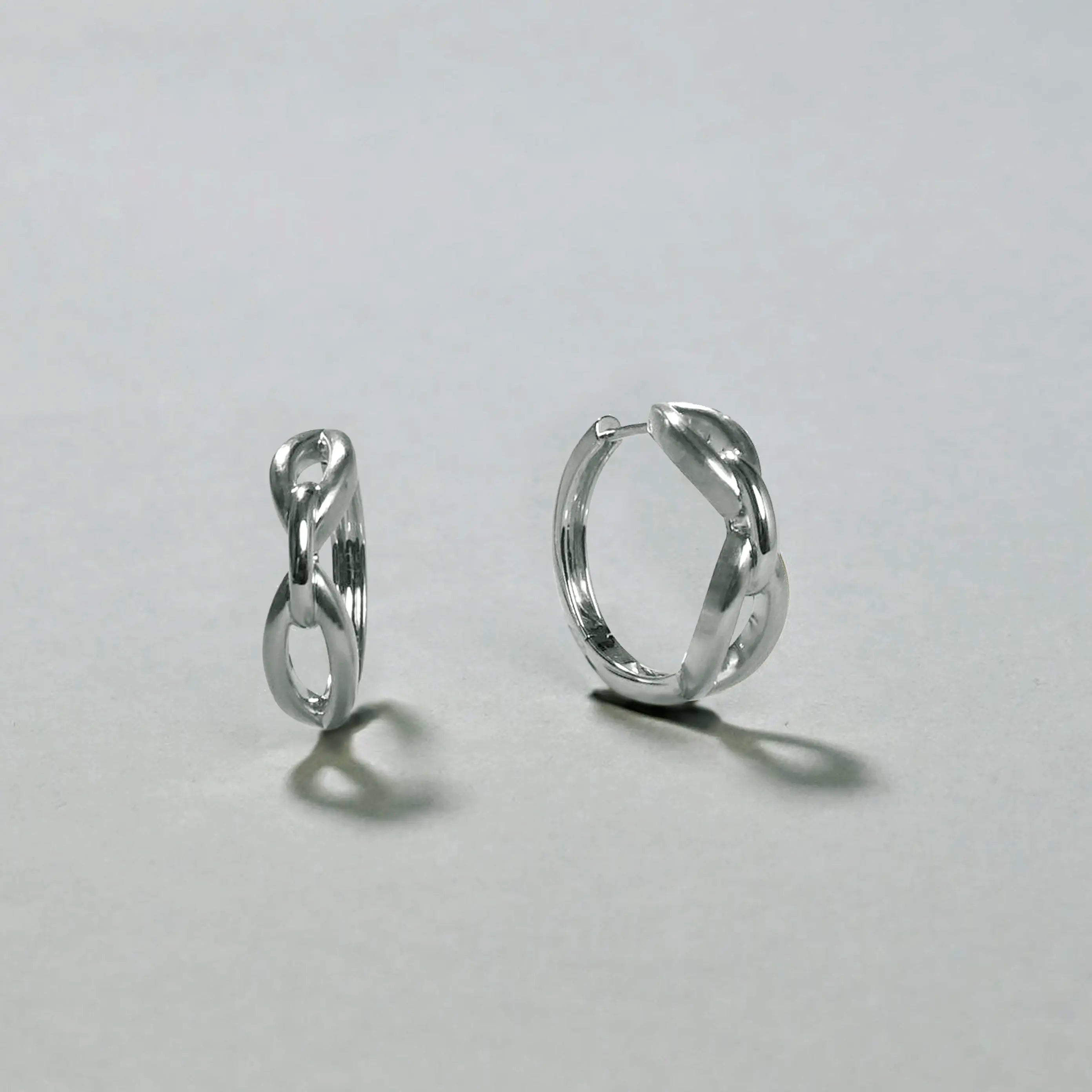 Pair of silver hoop earrings on a light gray background