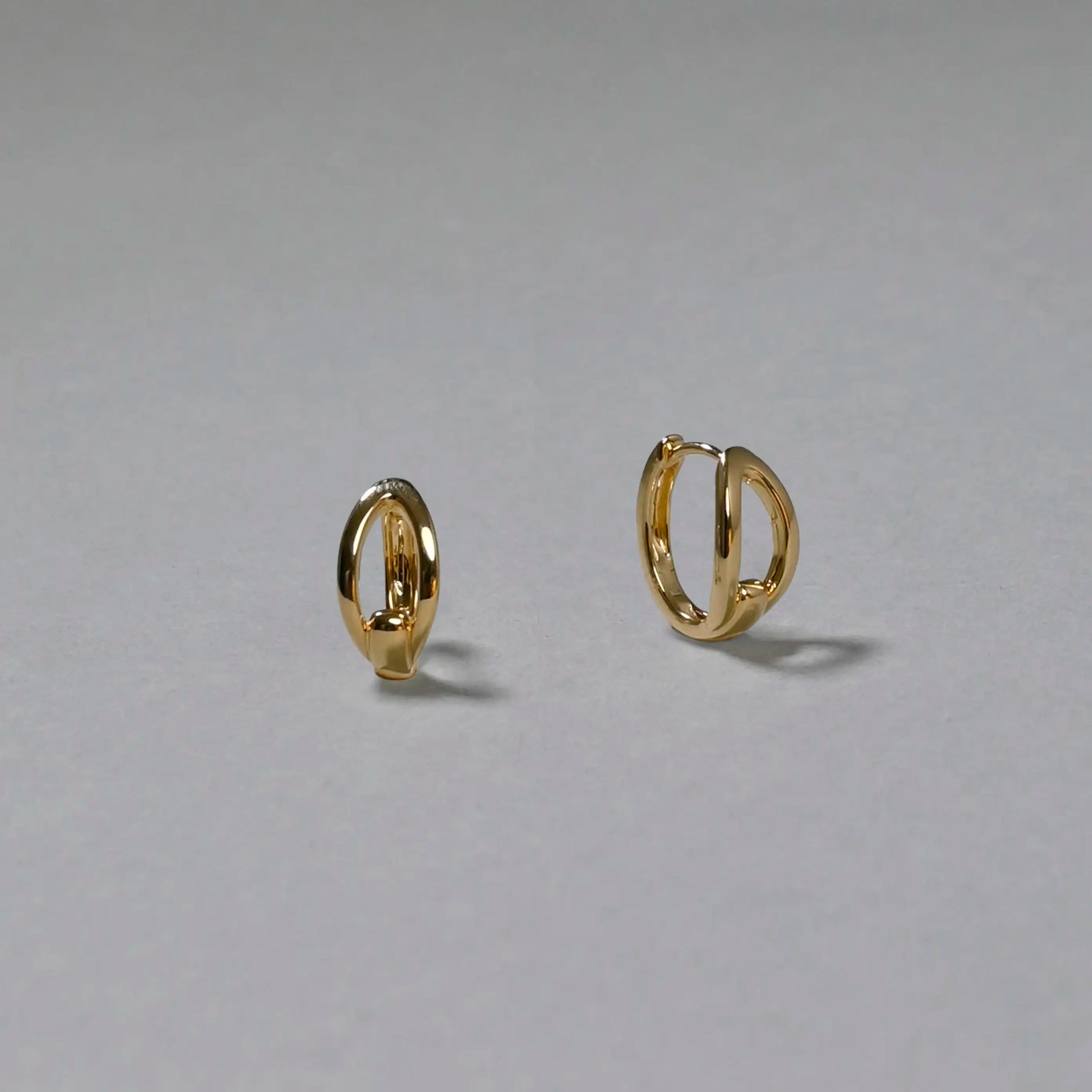 Gold hoop earrings on a gray background