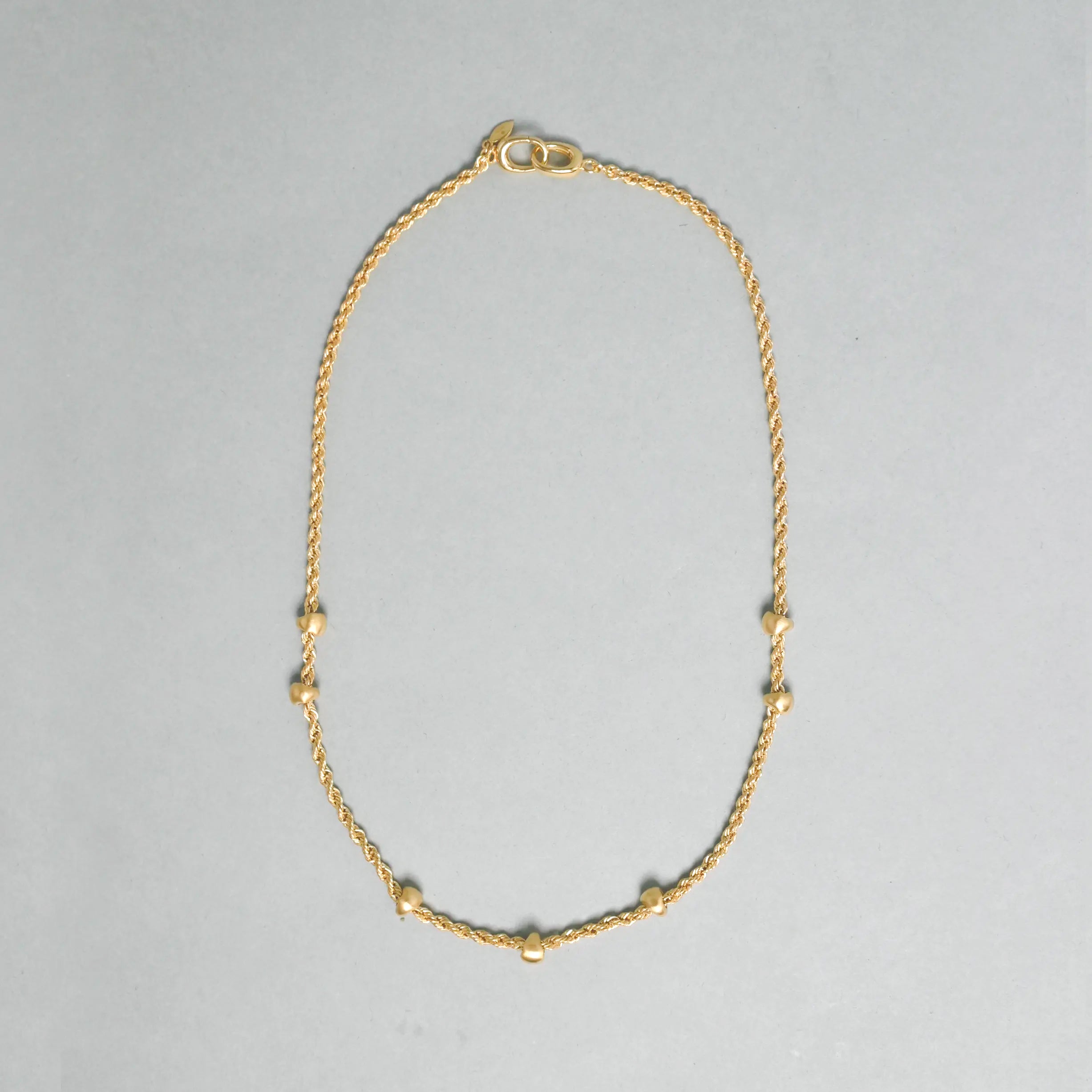 Gold necklace on a gray background