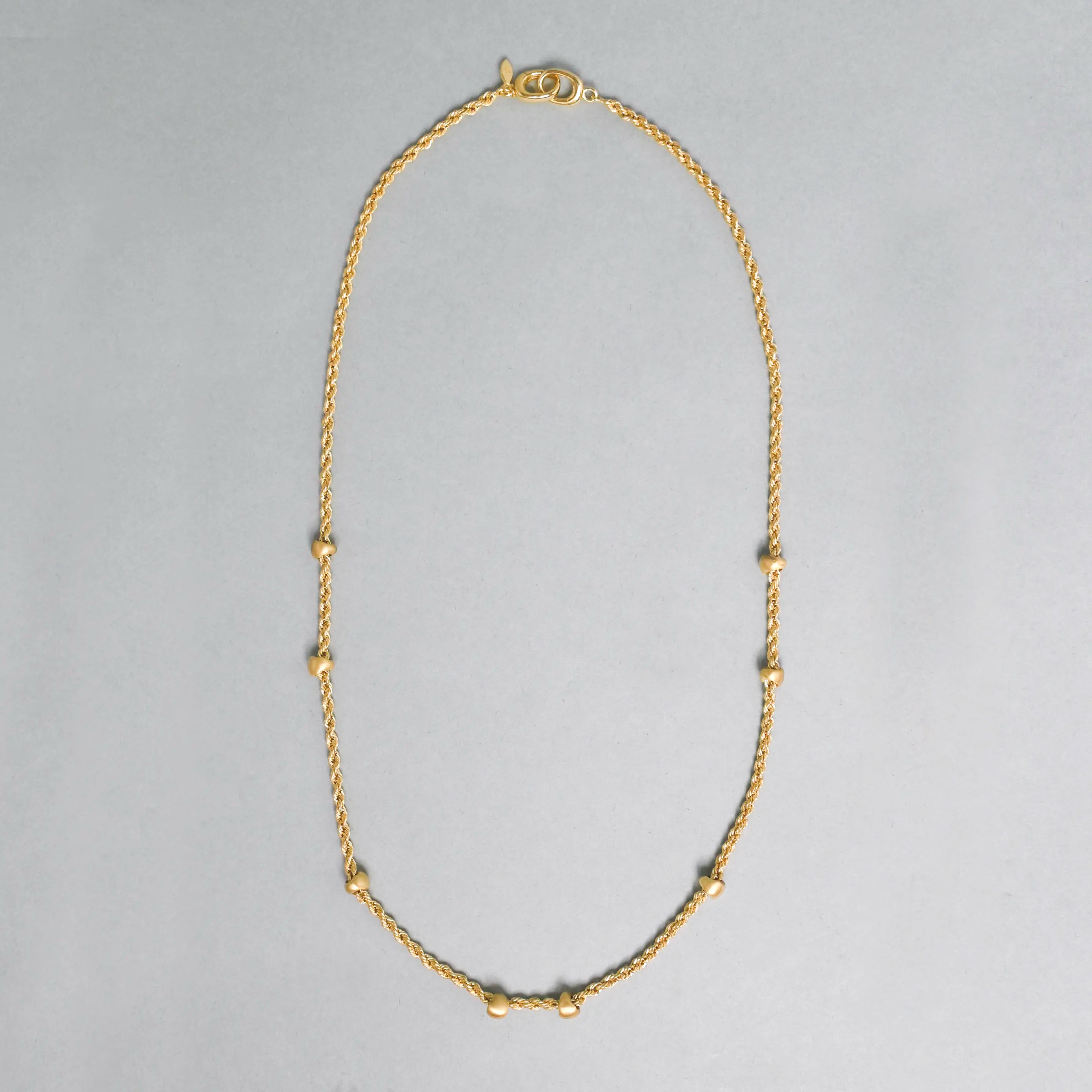 Gold necklace on a gray background
