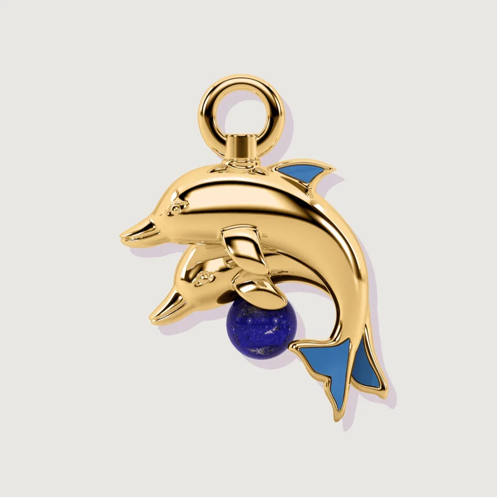 Gold dolphin charm with lapis lazuli bead and blue enamel fins on a plain background.