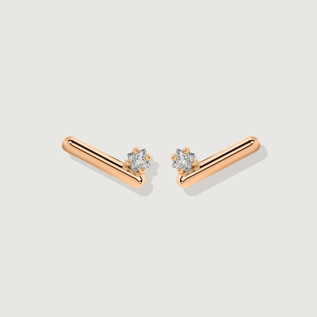 Pair of minimalist rose gold bar stud earrings with single round diamonds on white background