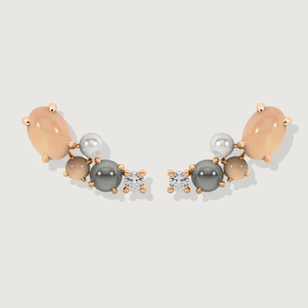 Pair of rose gold cluster stud earrings with peach moonstone, pearls, and sparkling crystals on a neutral background.