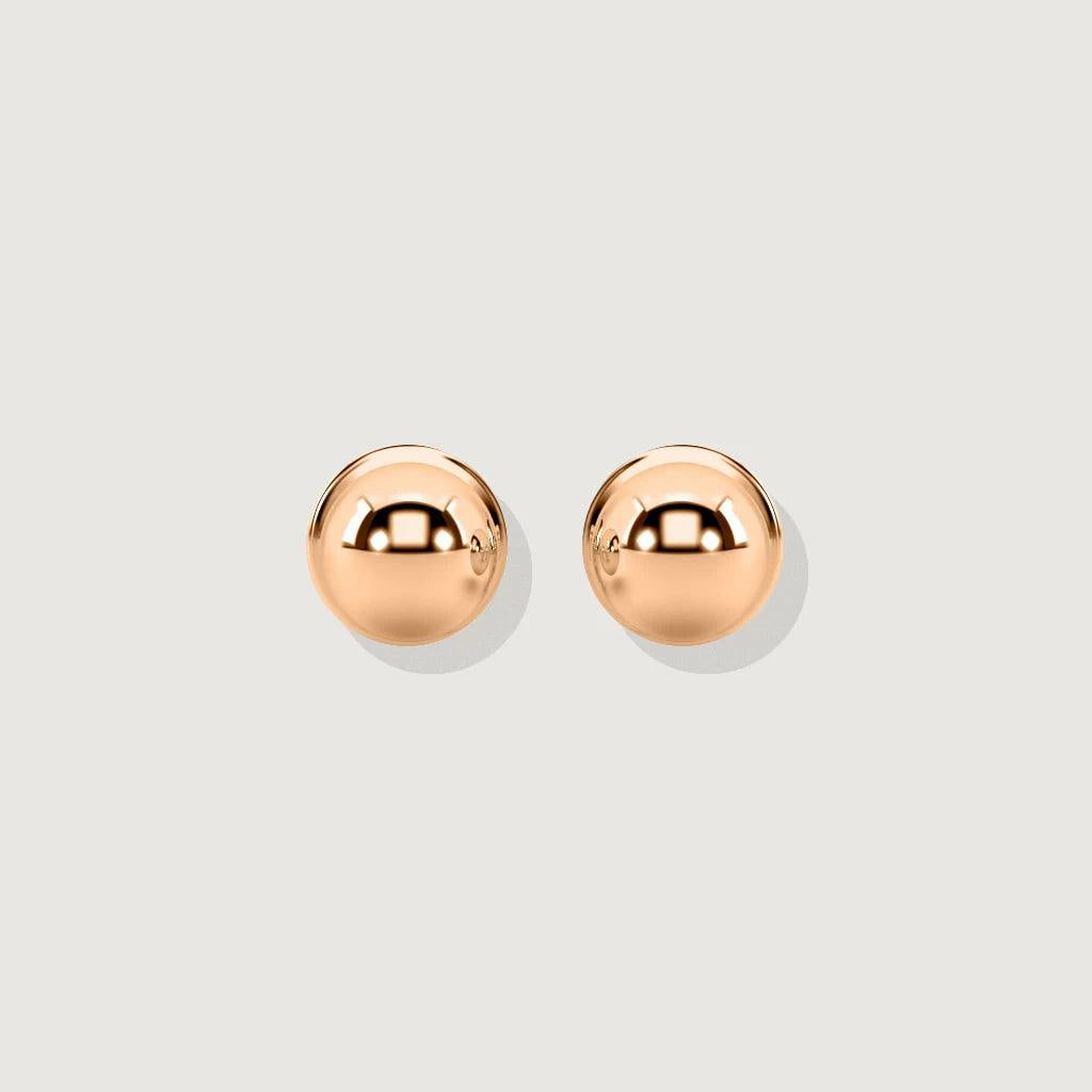 Product shot of a pair of polished rose gold ball stud earrings on a light grey background. The earrings are perfectly spherical and highly reflective.