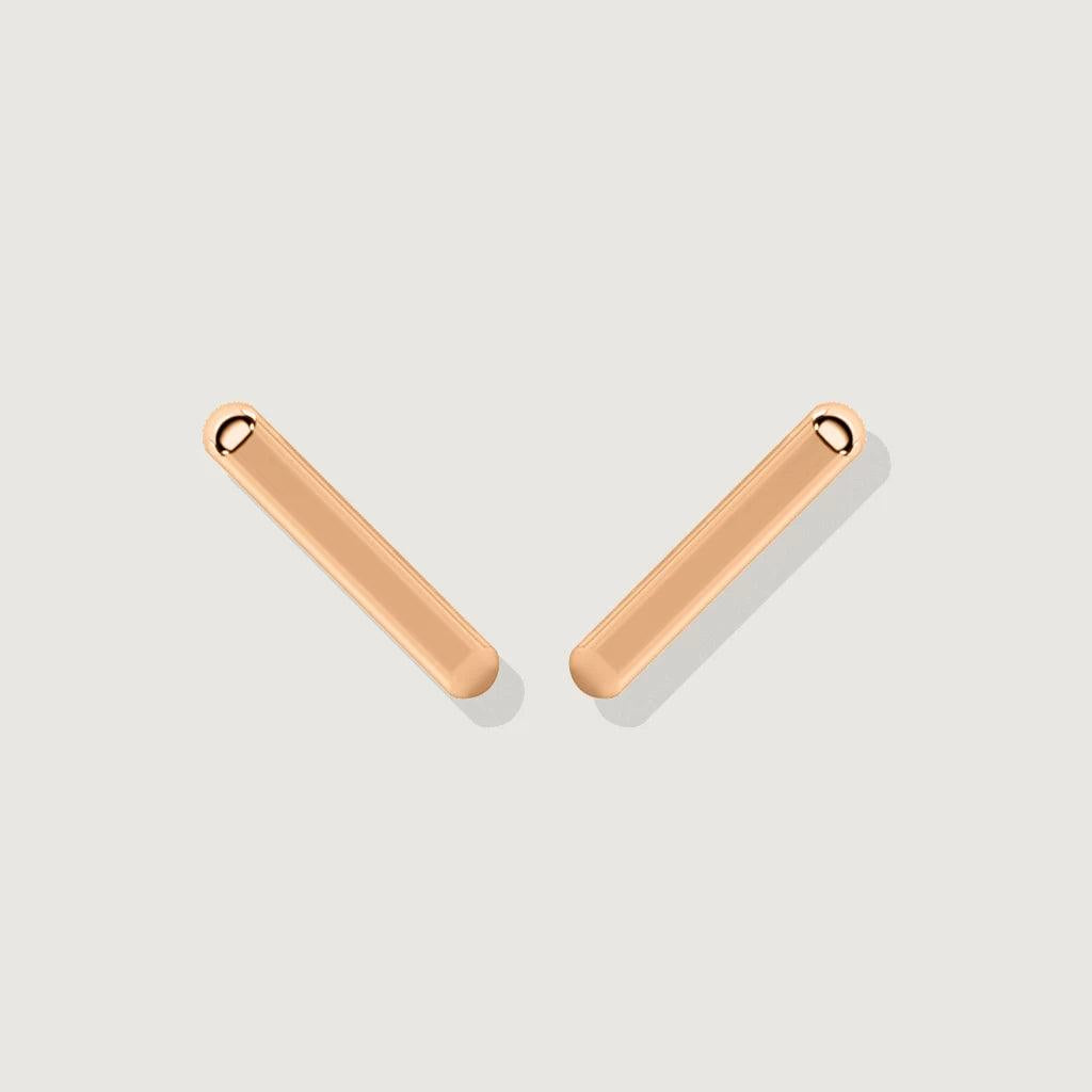 A pair of polished rose gold bar stud earrings photographed on a light background, simple and sleek design.