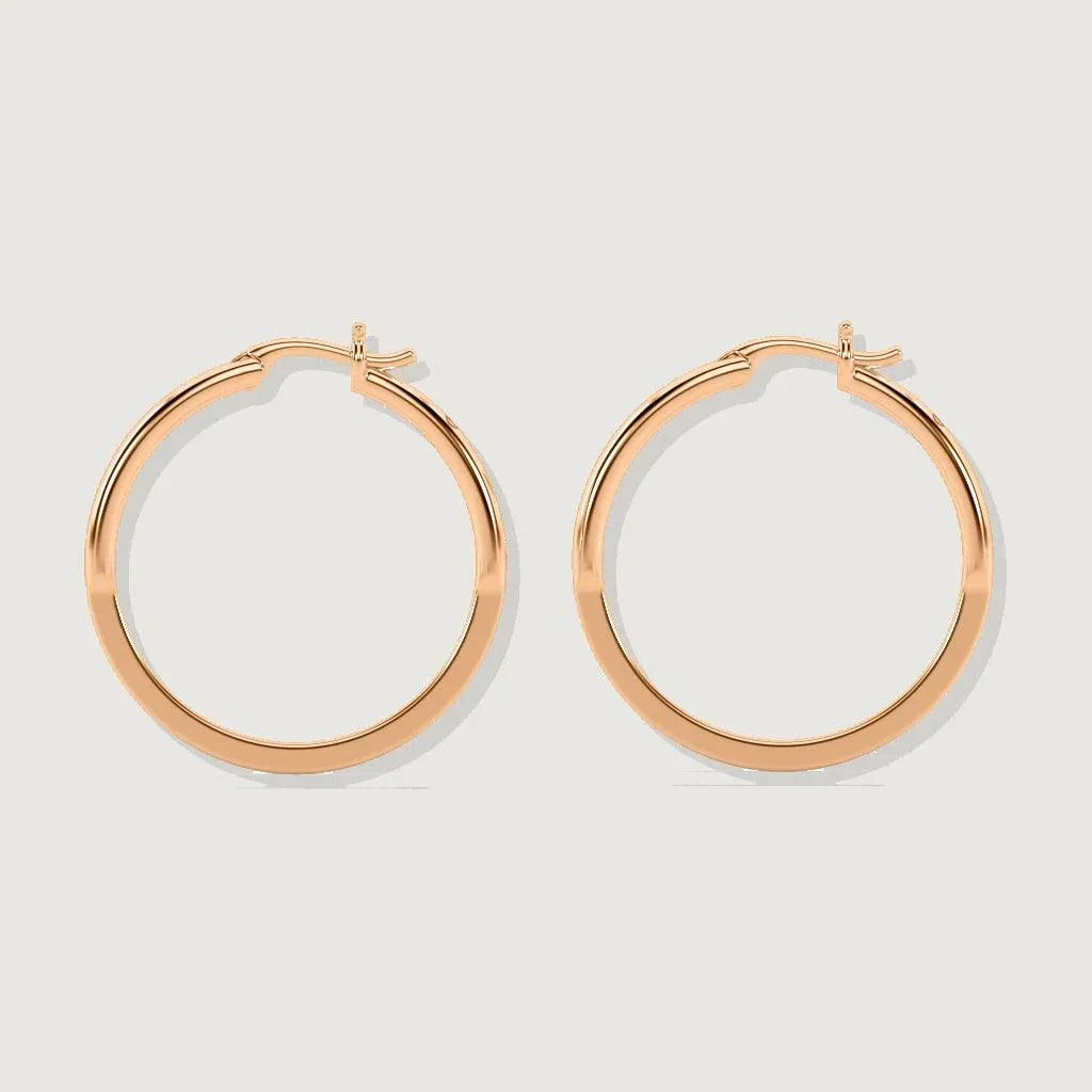 Product shot of a pair of rose gold shield-shaped hoop earrings with a hinged clasp, displayed on a light gray background.