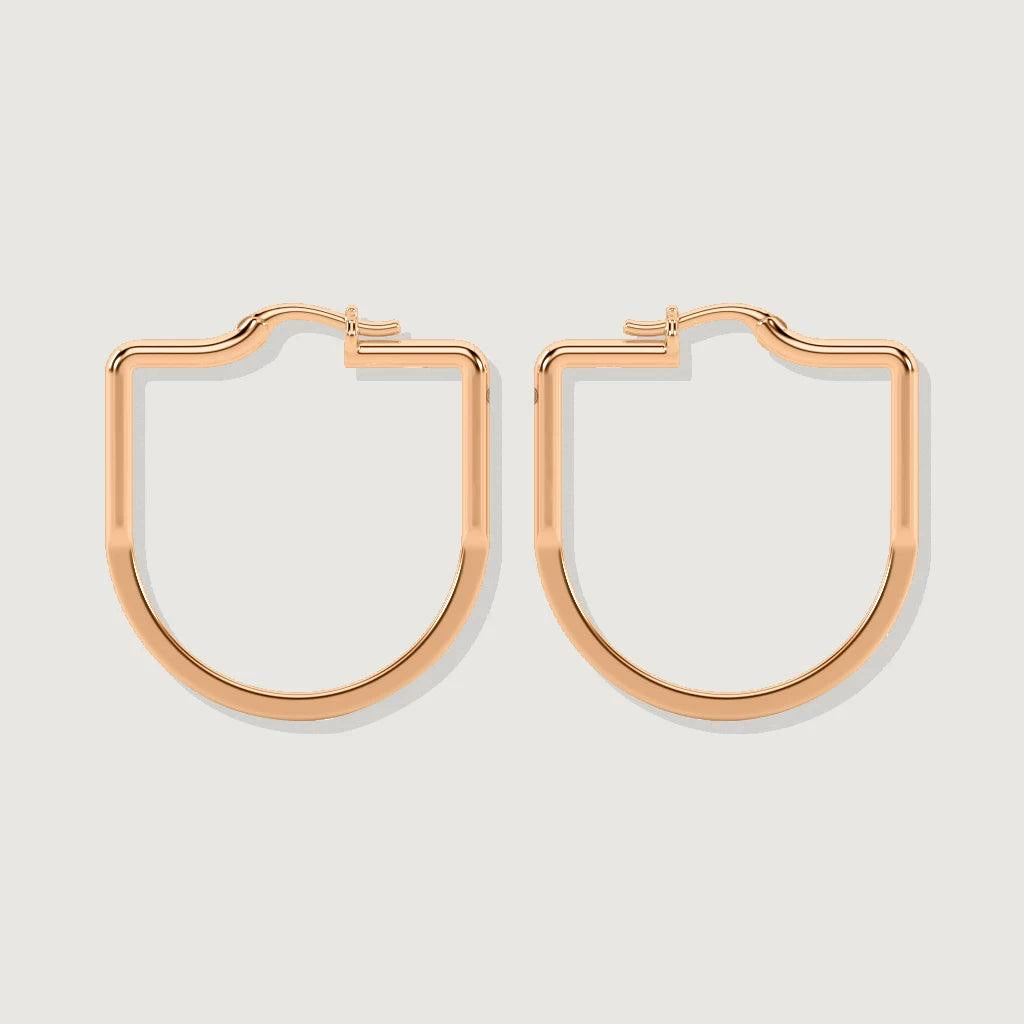Pair of rose gold geometric hoop earrings displayed on a plain light background, with a flat shield-like shape and smooth polished finish.