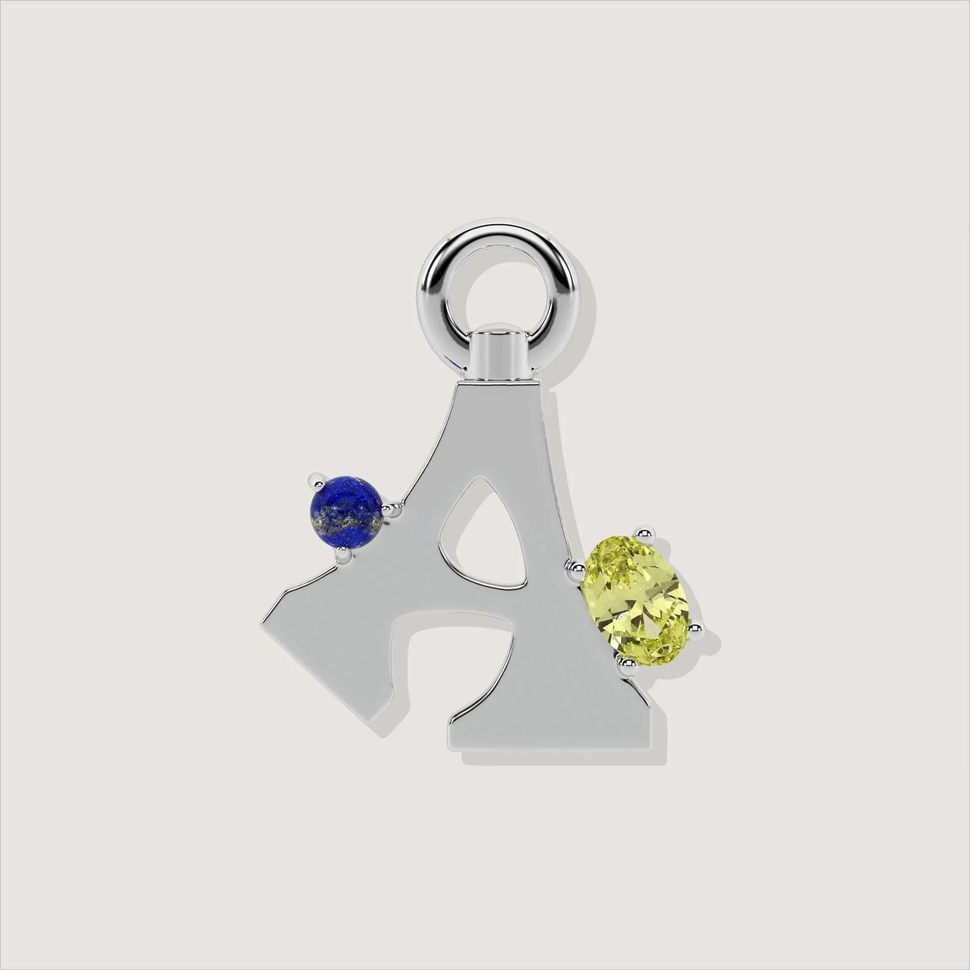 Close-up of silver letter A charm with blue and yellow gemstones.