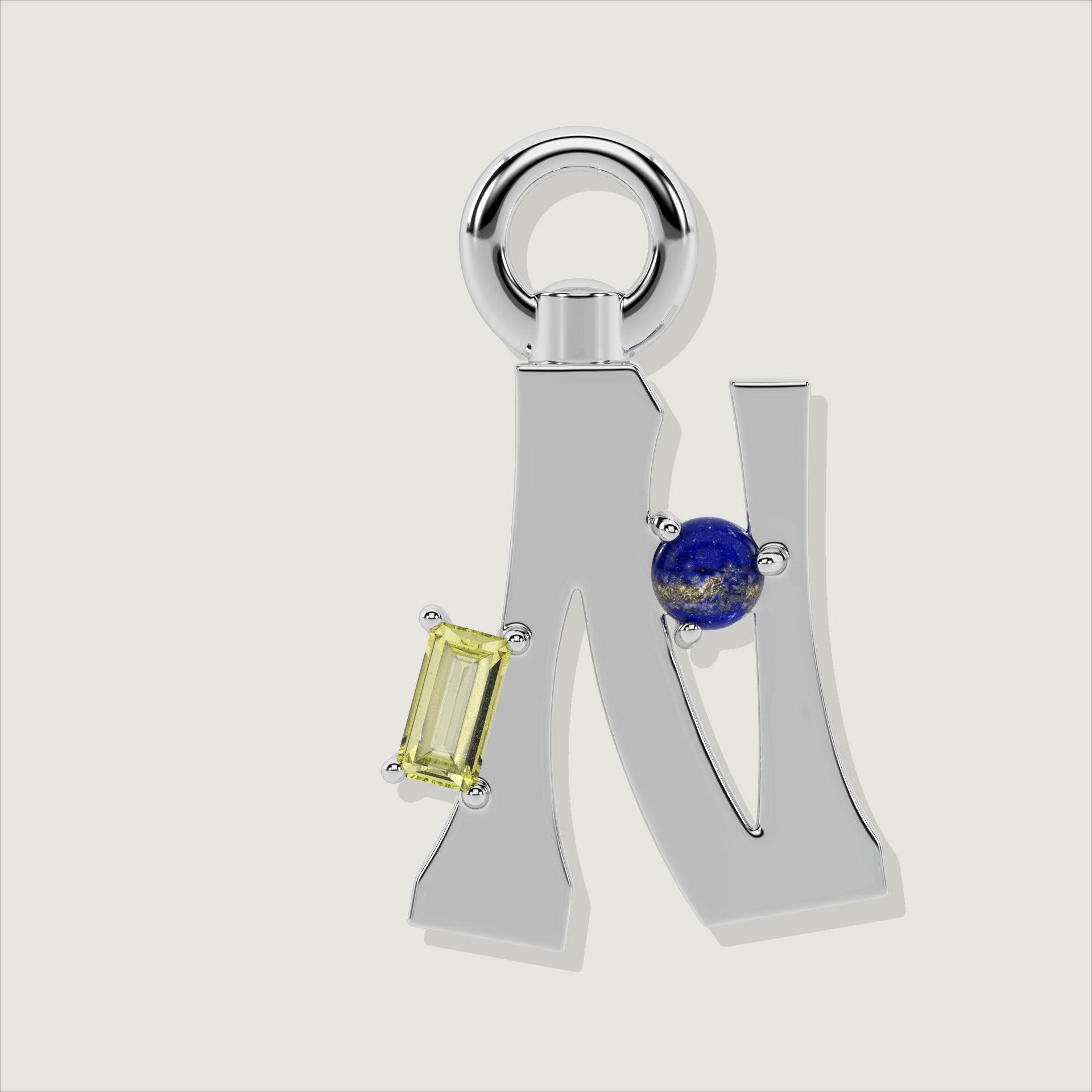 Silver letter N charm with a yellow baguette-cut gem and a round lapis-blue stone.