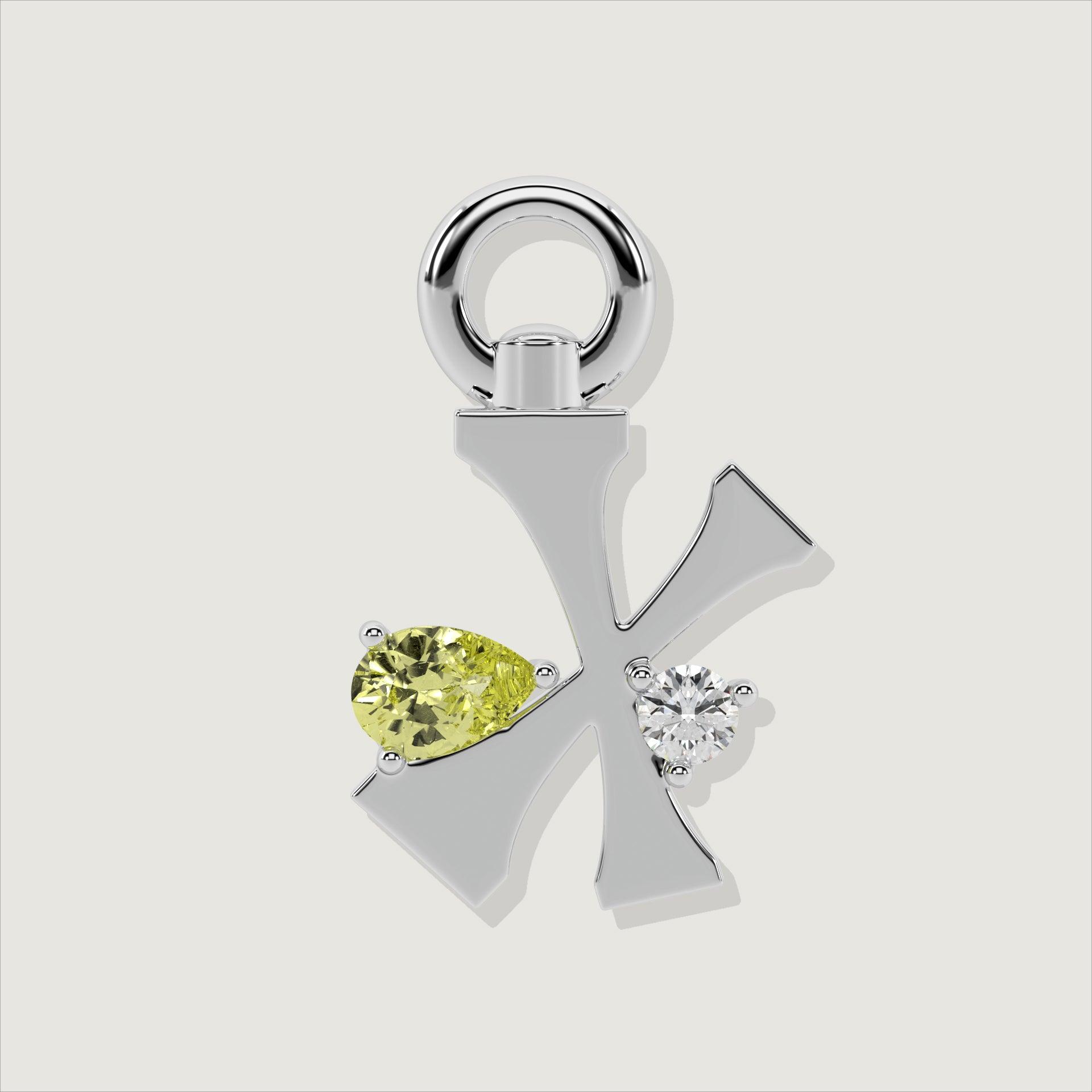 Silver letter X charm decorated with a pear-cut yellow gemstone and a clear round stone.