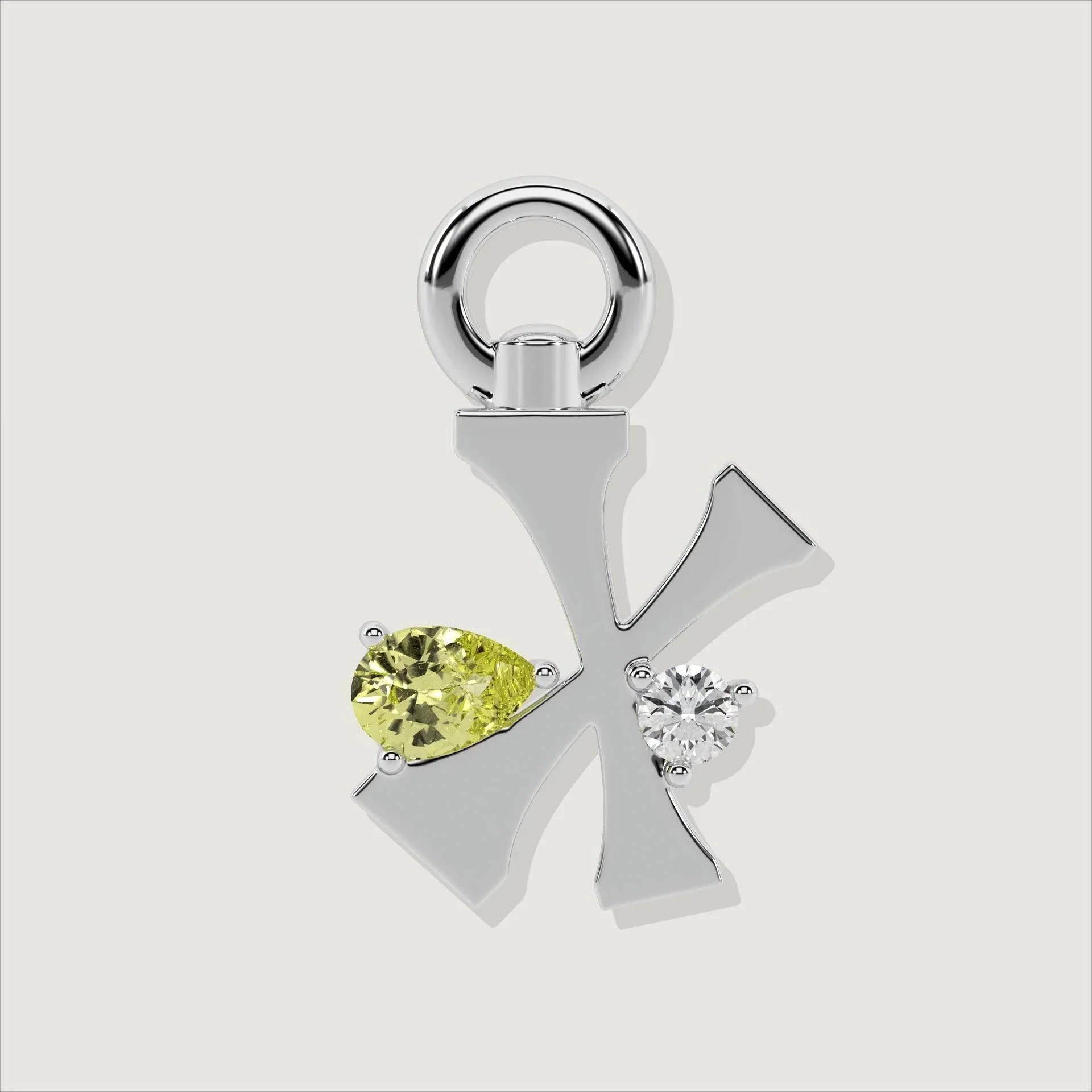 Silver letter X charm decorated with a pear-cut yellow gemstone and a clear round stone.