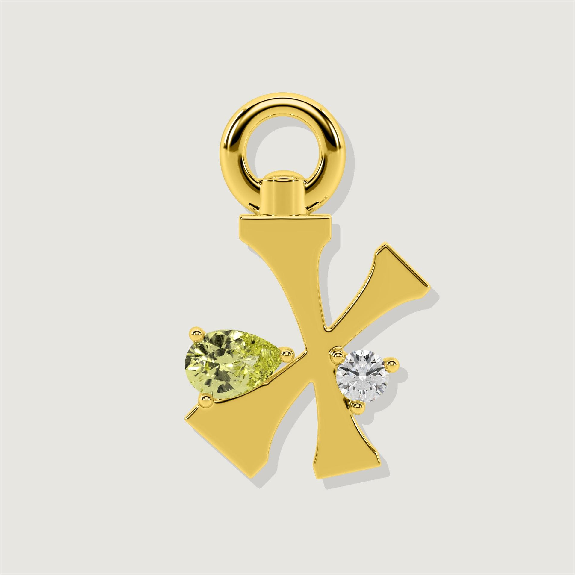 Gold letter X charm decorated with a pear-cut yellow gemstone and a clear round stone.