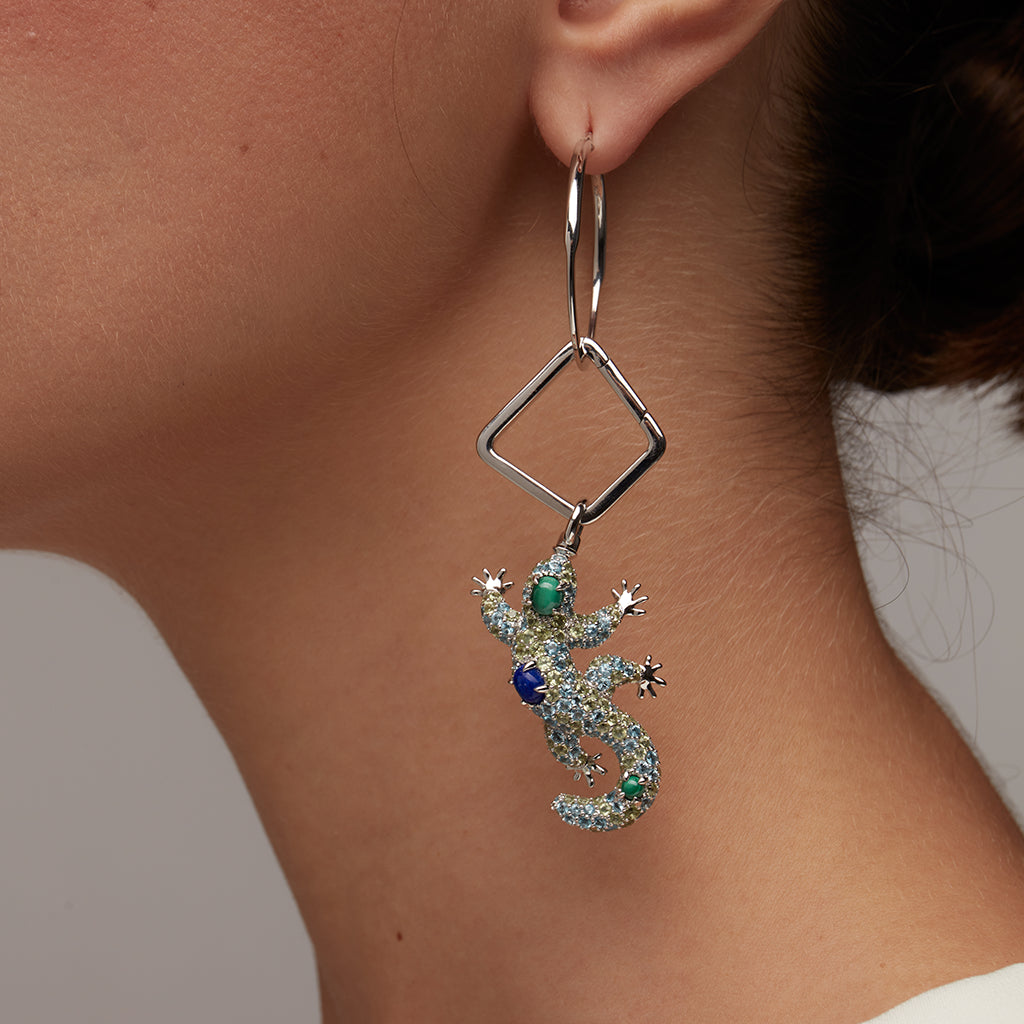 Silver geometric hoop earring with sparkling lizard charm adorned with green and blue gemstones