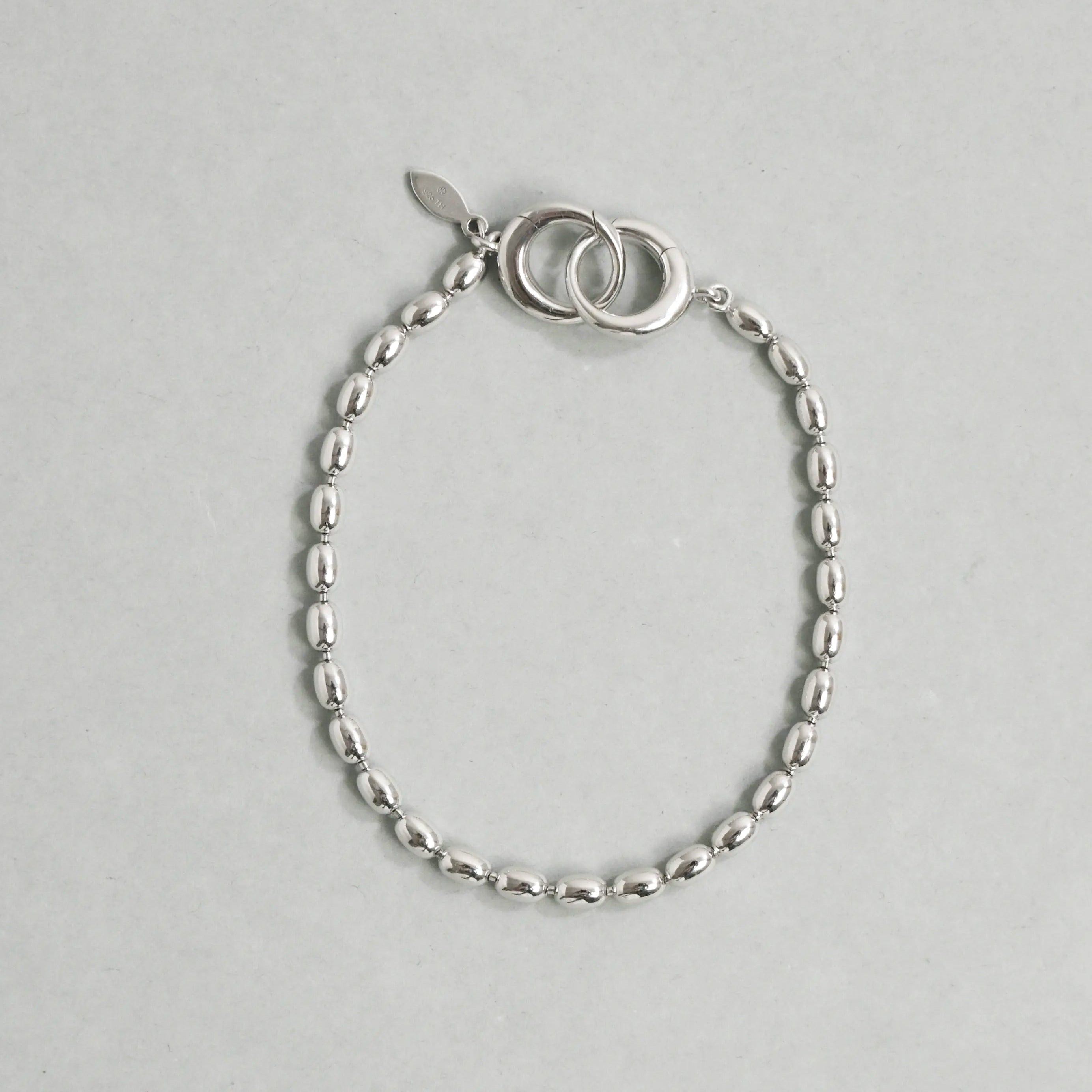 Silver bracelet with a simple design on a light gray background