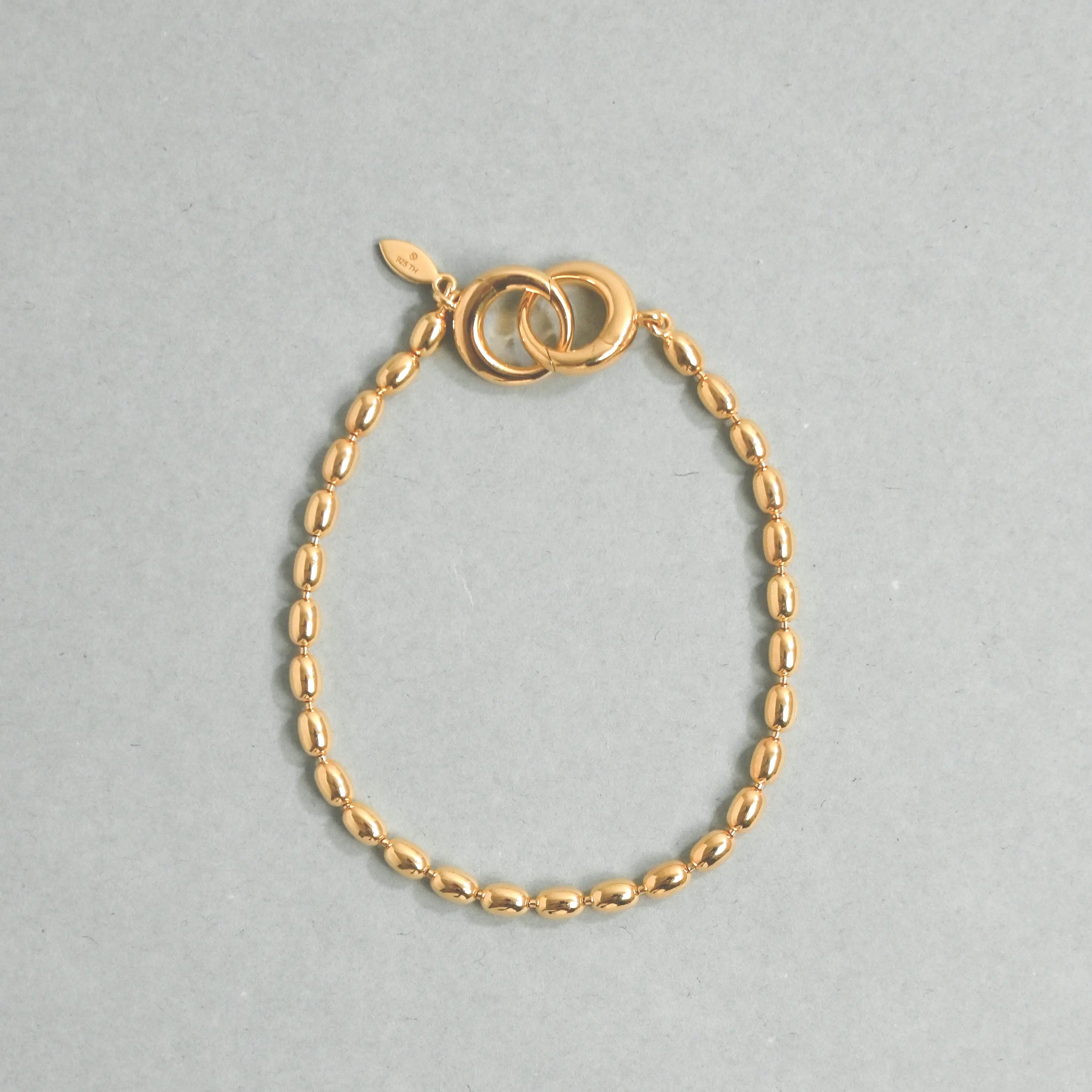 Gold bracelet on a light gray background