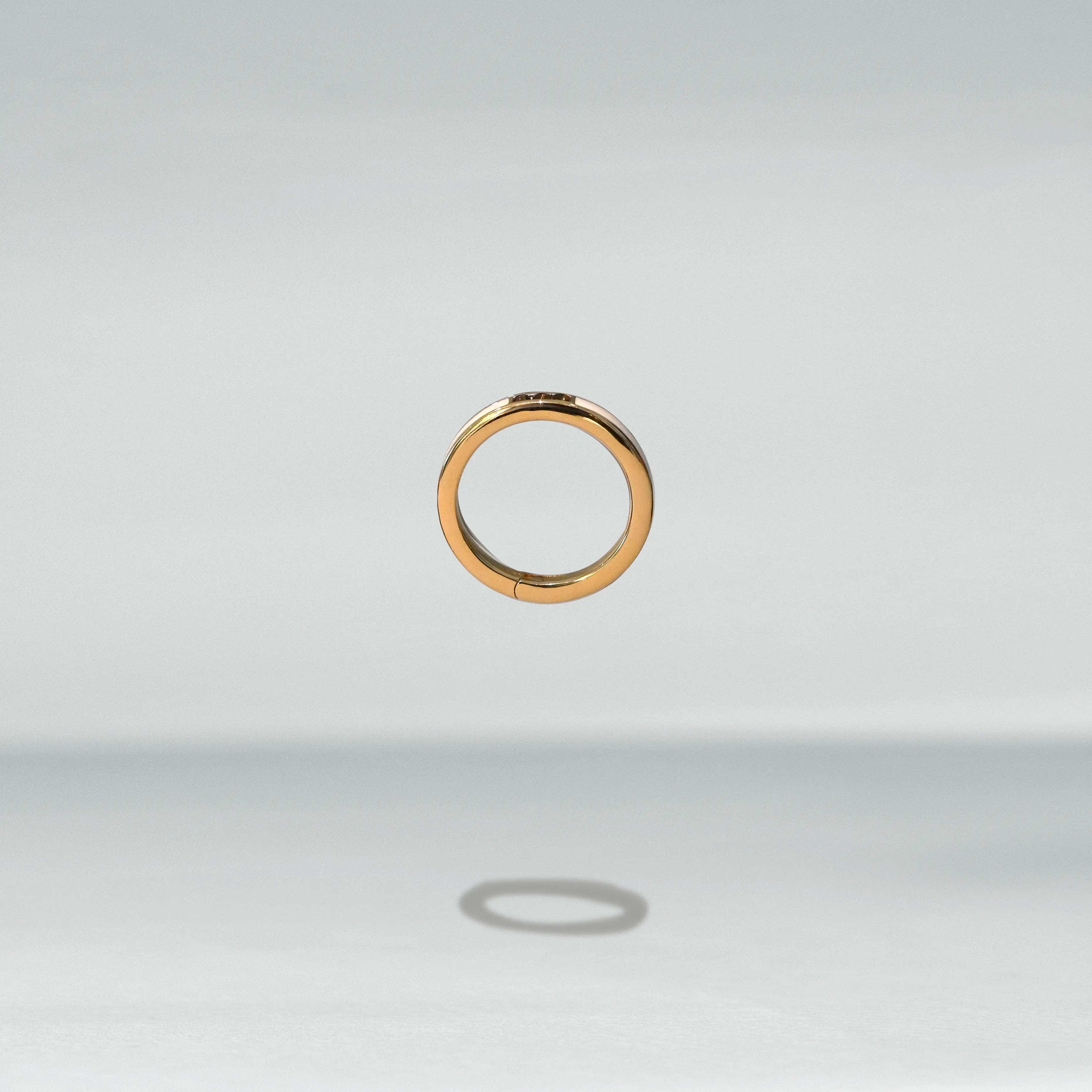 Gold ring on a light gray background