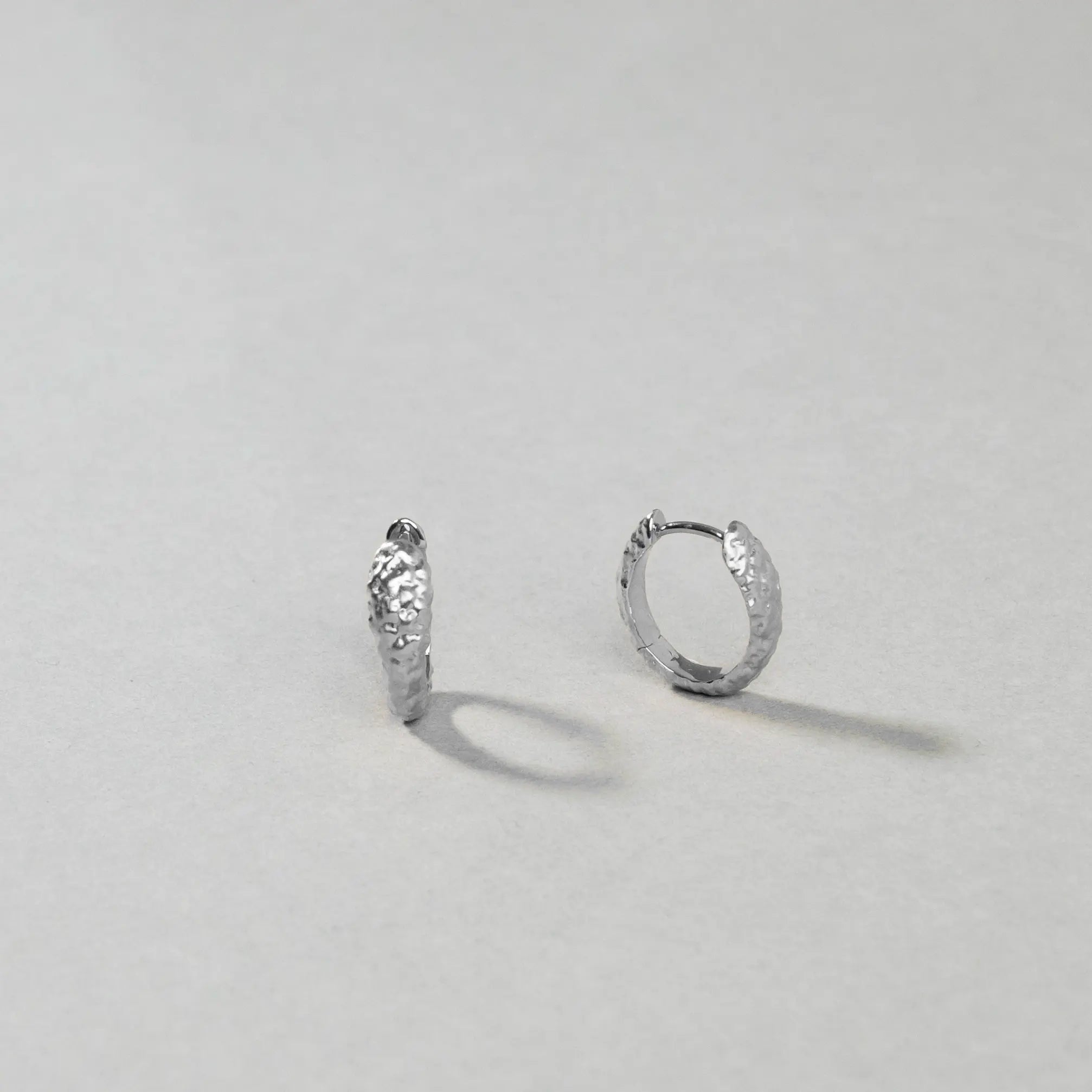 Pair of silver hoop earrings on a light gray background