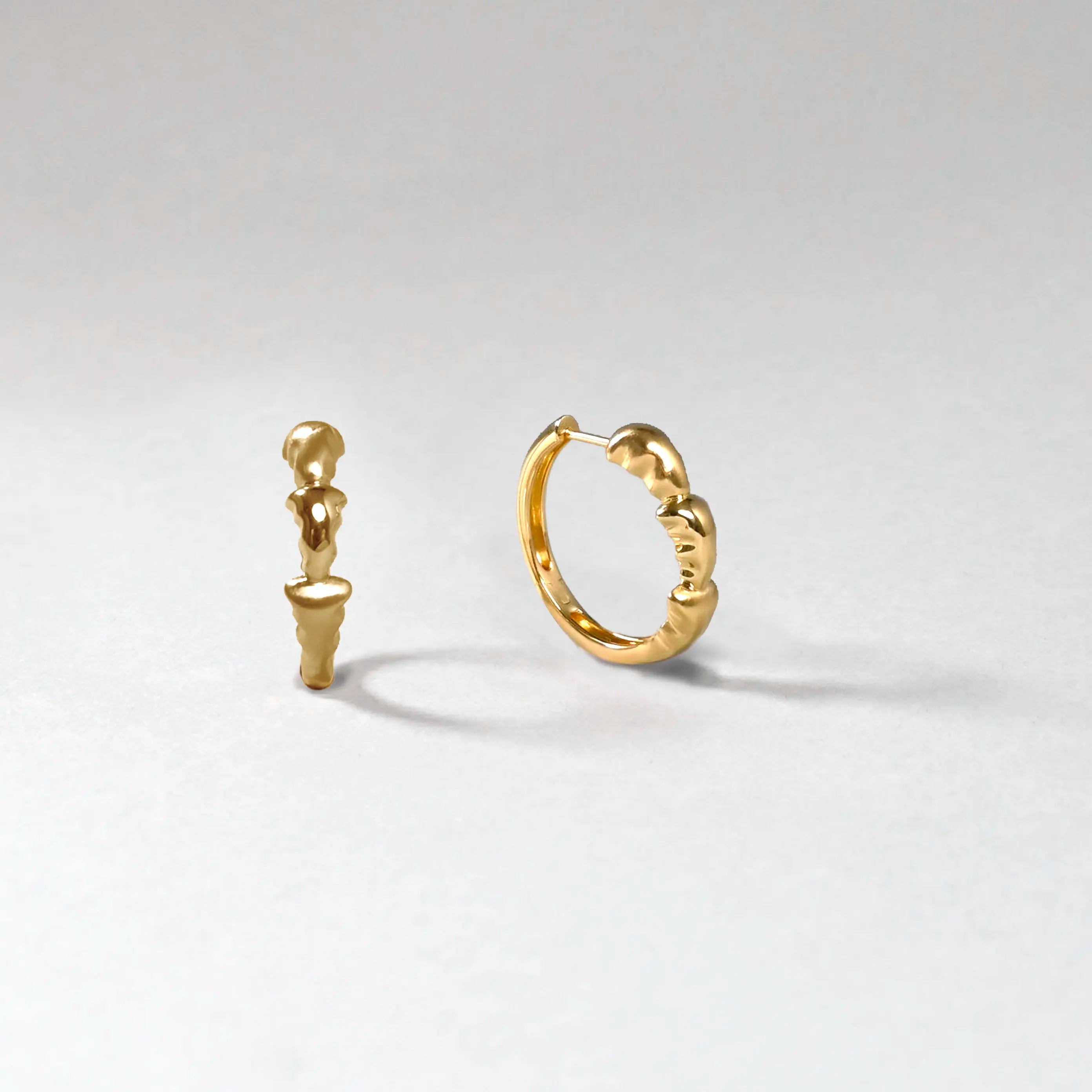 Gold hoop earrings on a light gray background