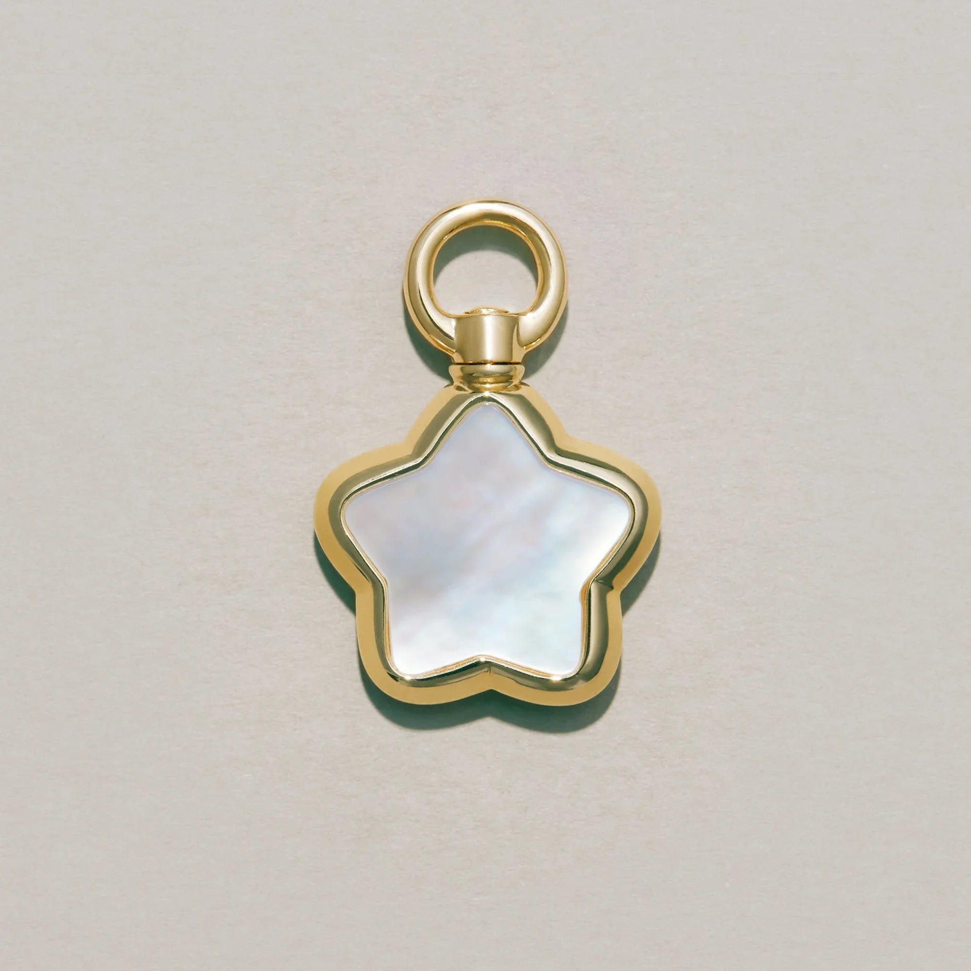 Gold star-shaped charm with a white center on a light gray background