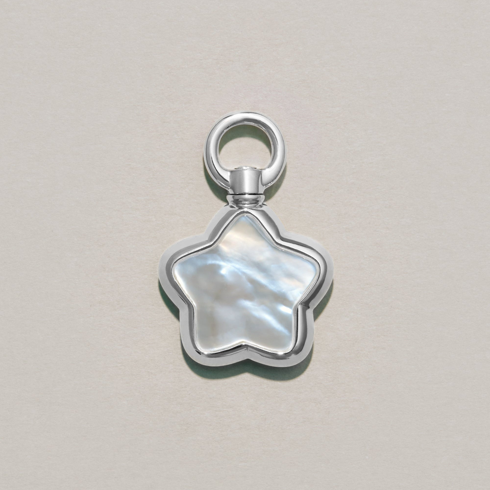Star-shaped silver charm on a light gray background