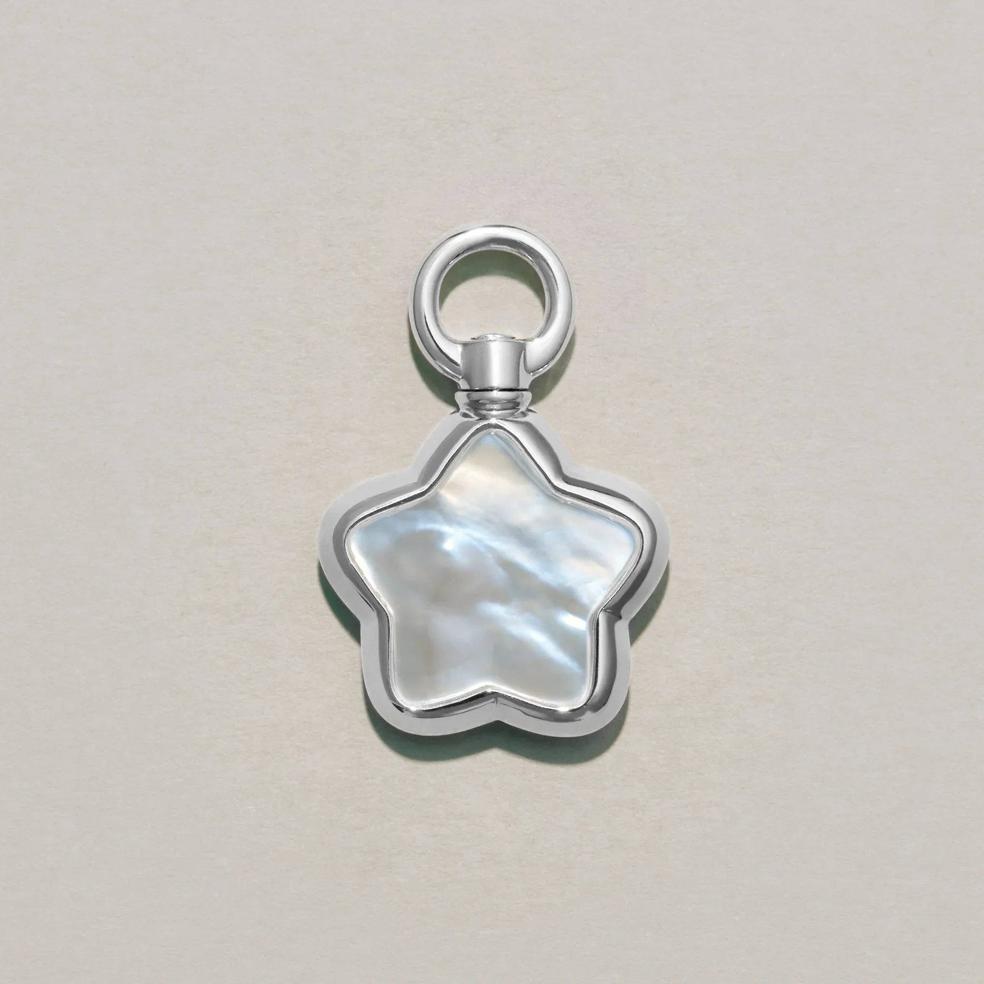 Star-shaped silver charm on a light gray background