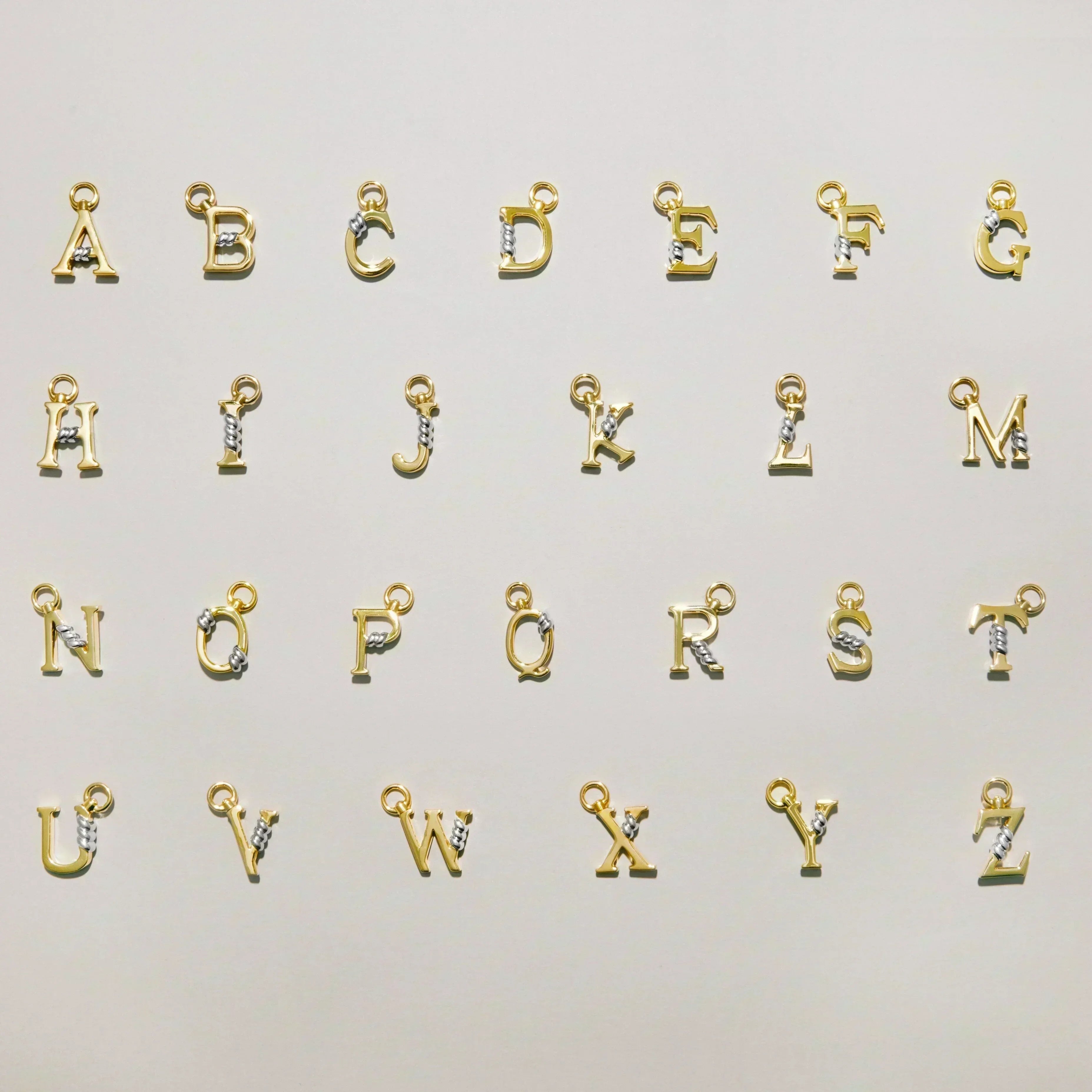 Full A to Z collection of gold letter charms each featuring a gold rope twist detail, arranged on a light background.