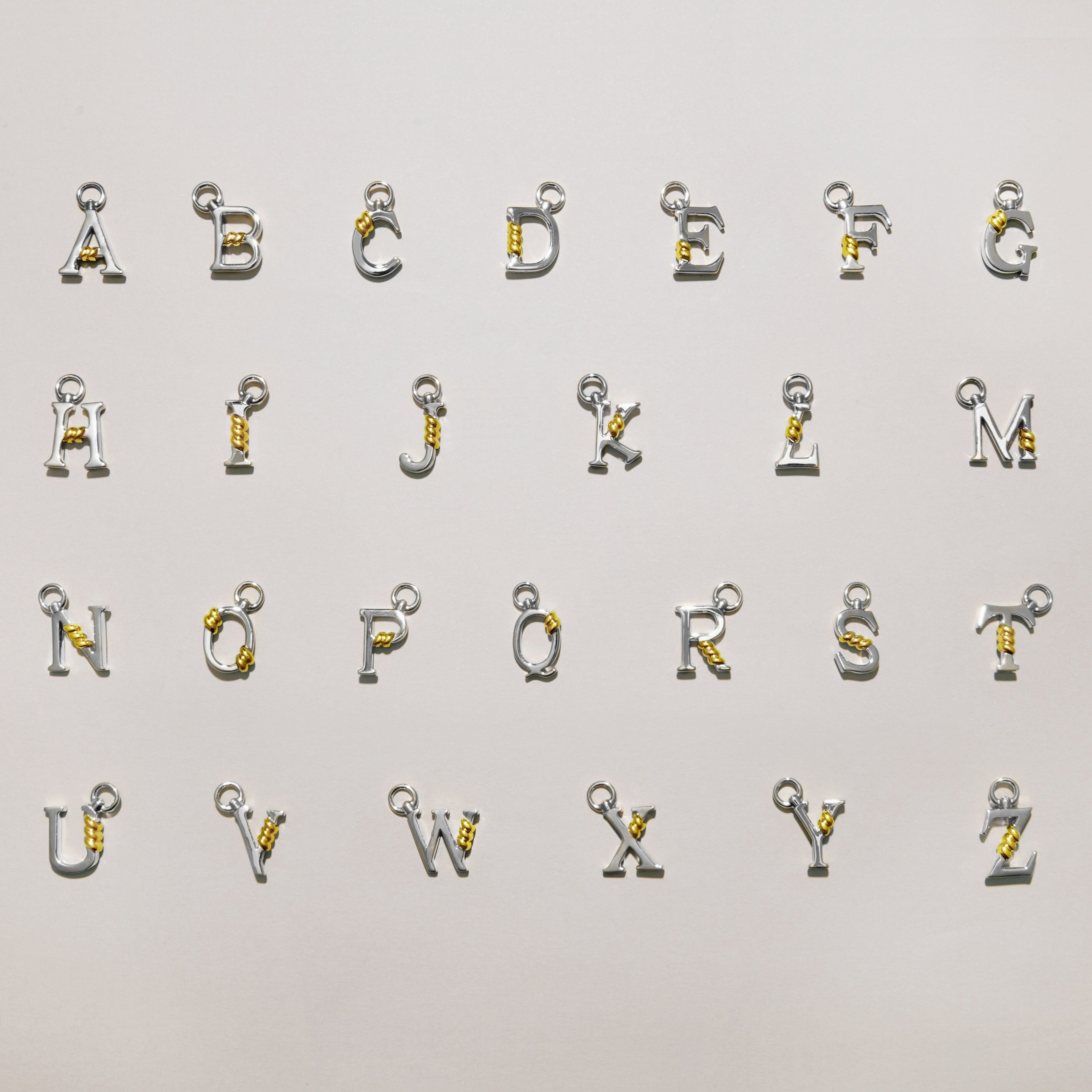 Full A to Z collection of silver letter charms each featuring a gold rope twist detail, arranged on a light background.