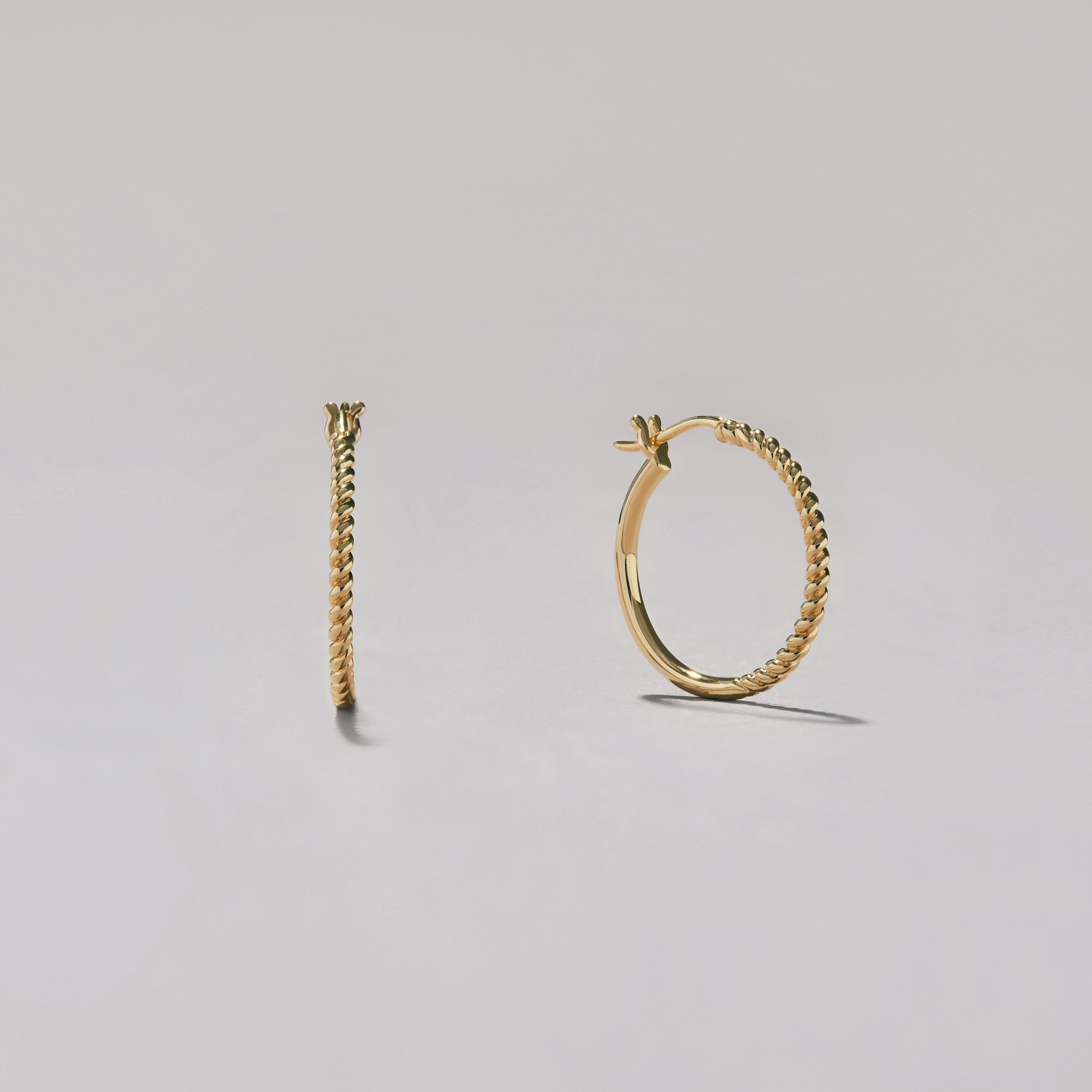 Gold hoop earrings on a light gray background