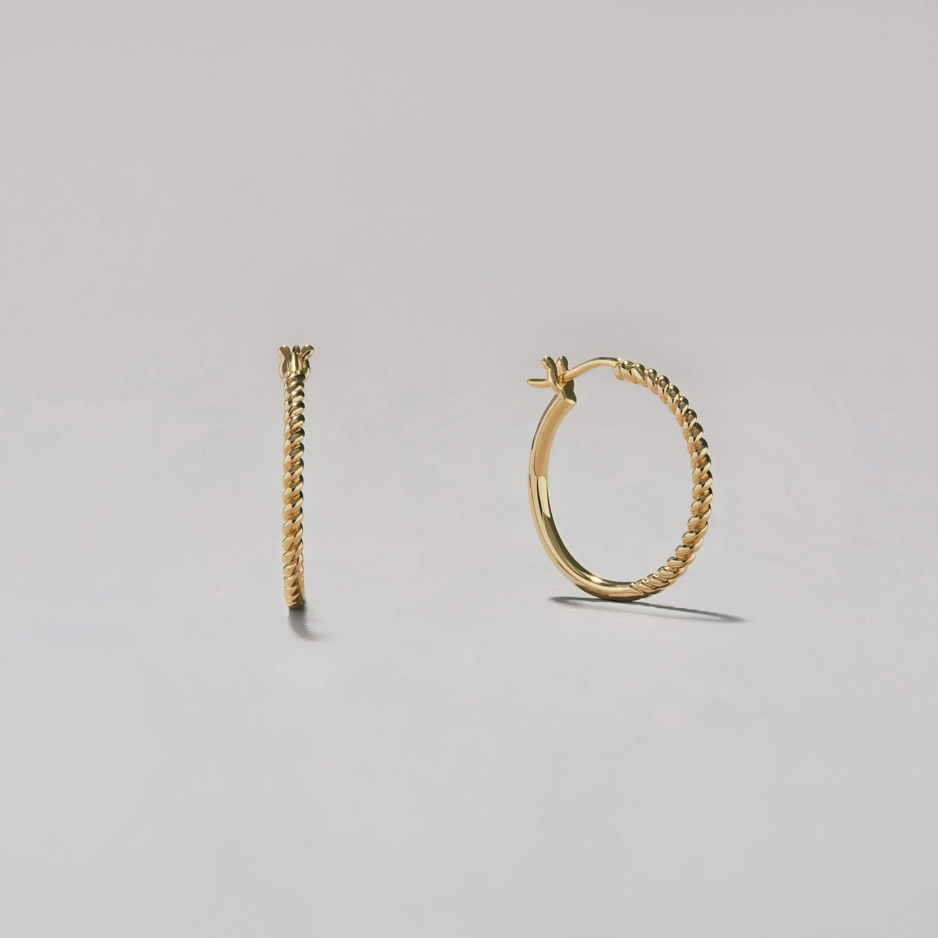 Gold hoop earrings on a light gray background