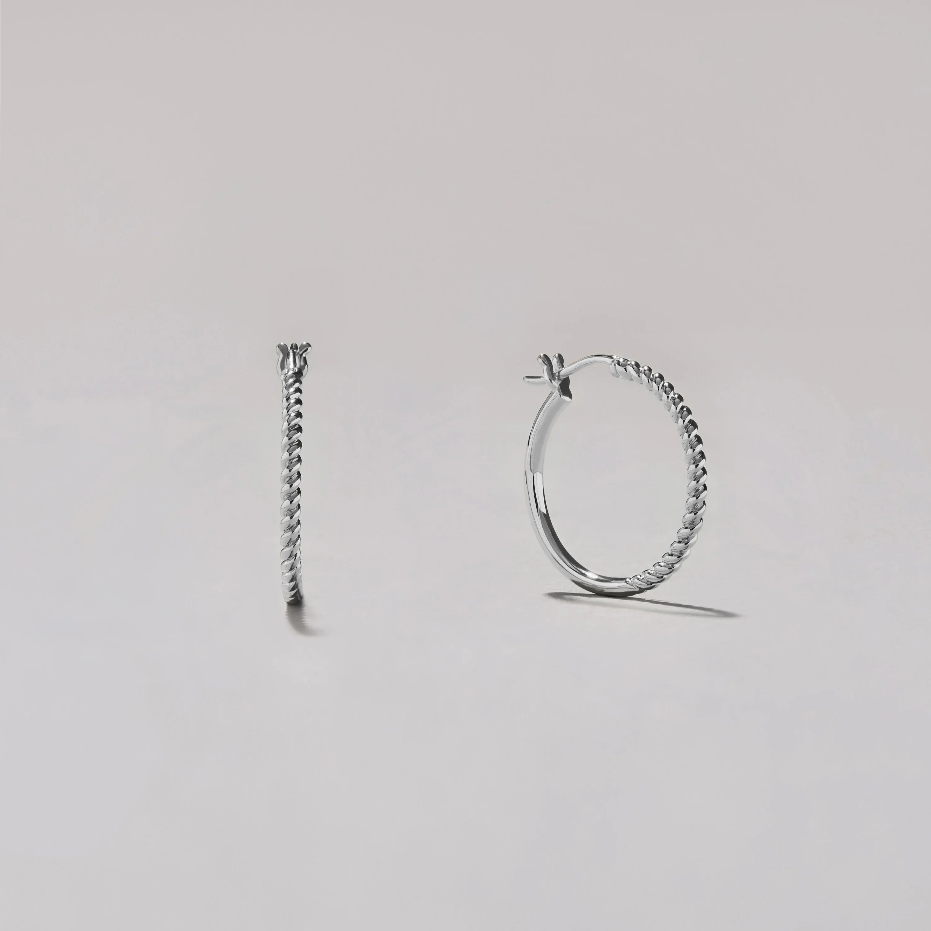 Silver hoop earrings on a light gray background